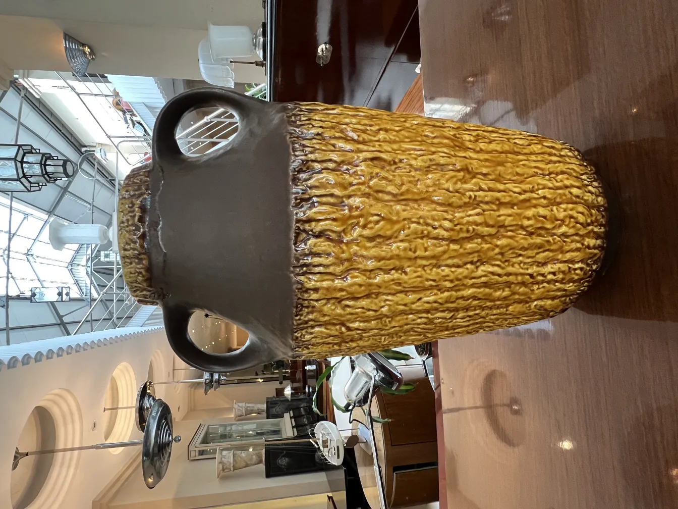 Vaso de cerâmica antiga com textura amarela e marrom, detalhes decorativos