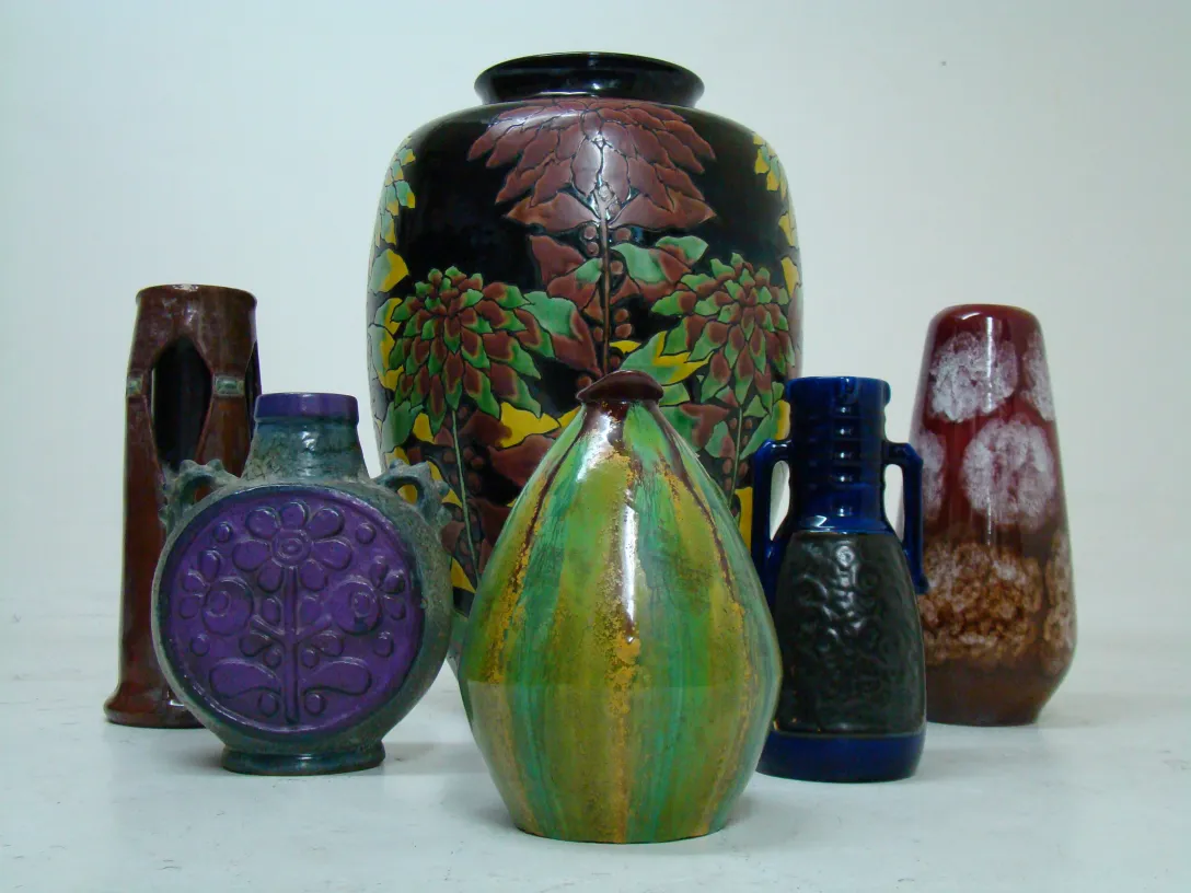 Conjunto de antiguas cerâmicas decorativas de várias cores e formas.
