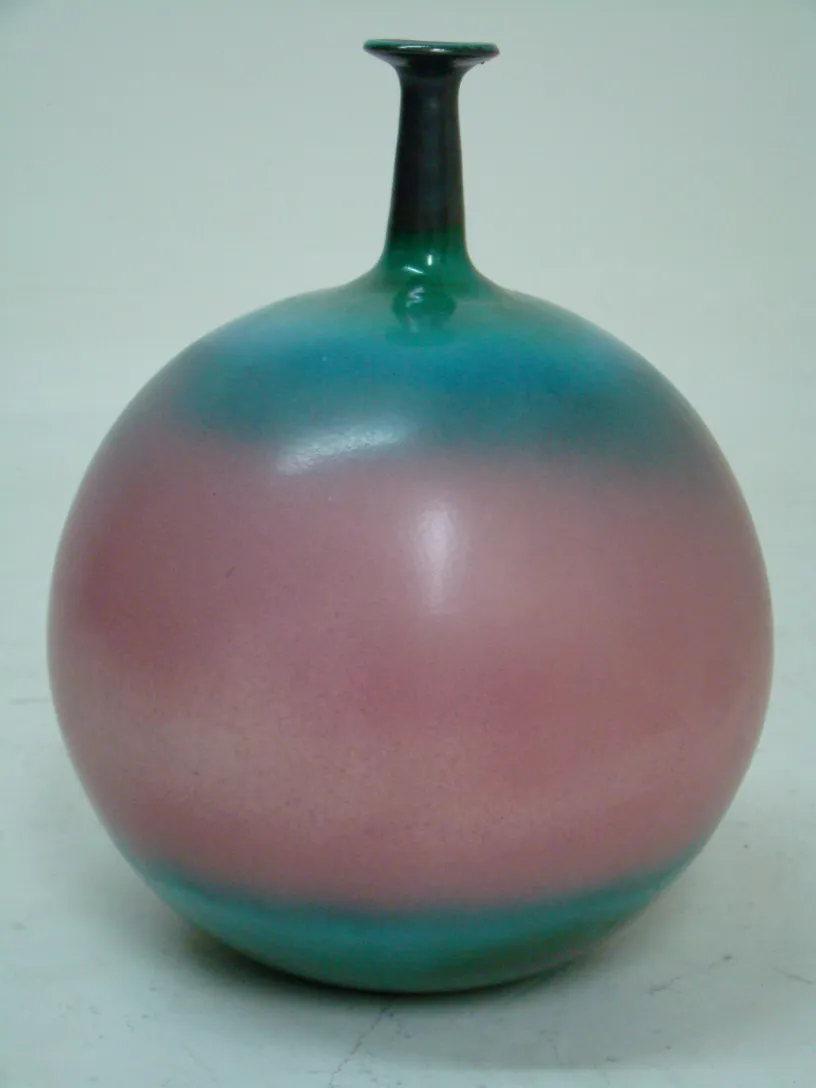 Jarra de cerámica antigua con tonos de azul y rosa