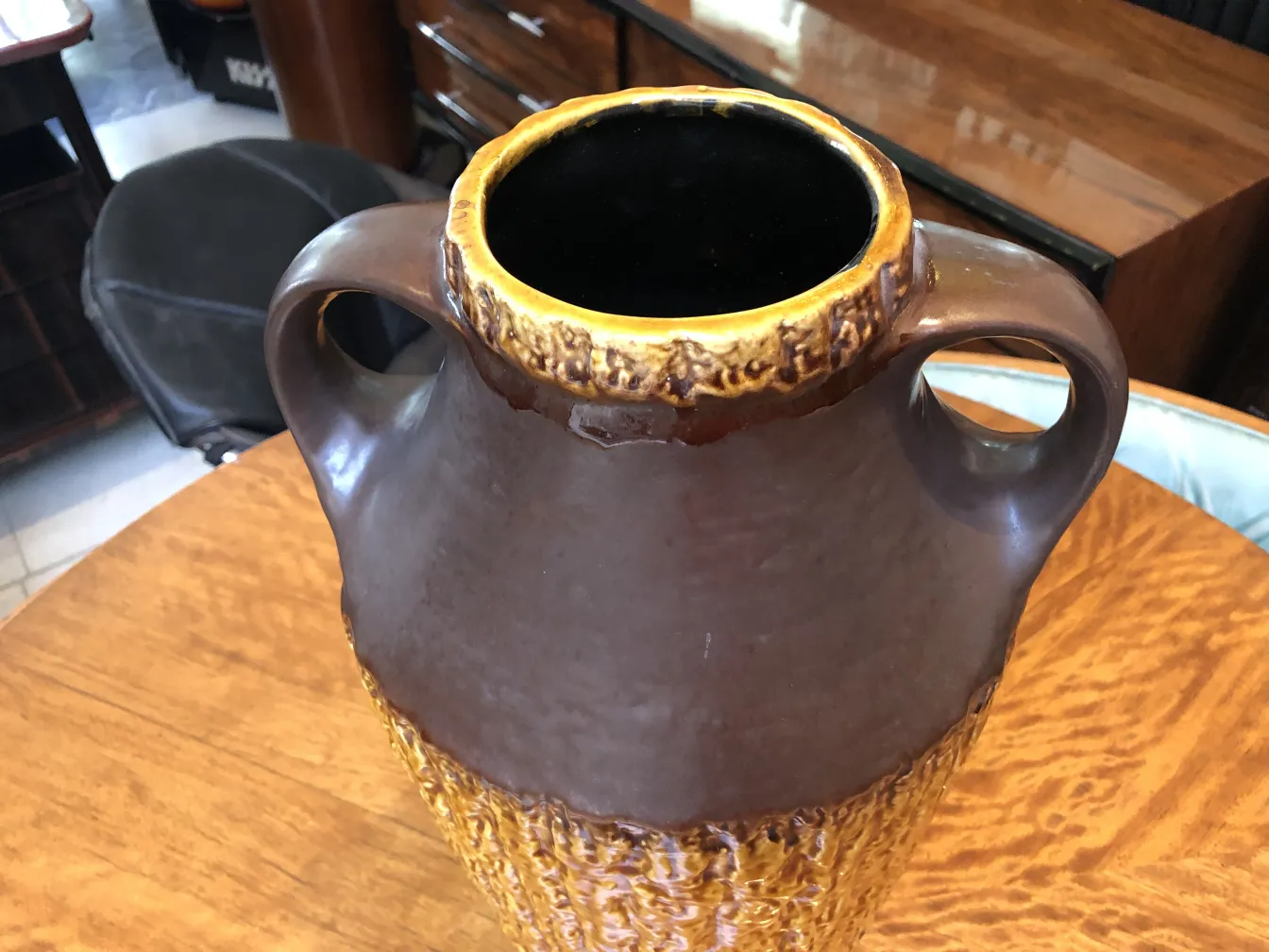 黄色のディテールと取っ手のある茶色の古い陶器のジャグ