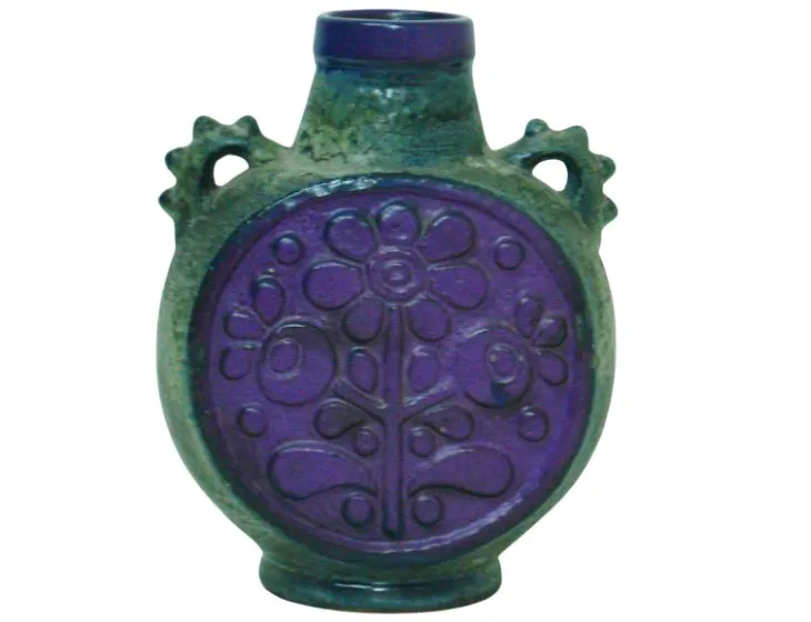 Antique ceramic jug with a purple and green floral design.