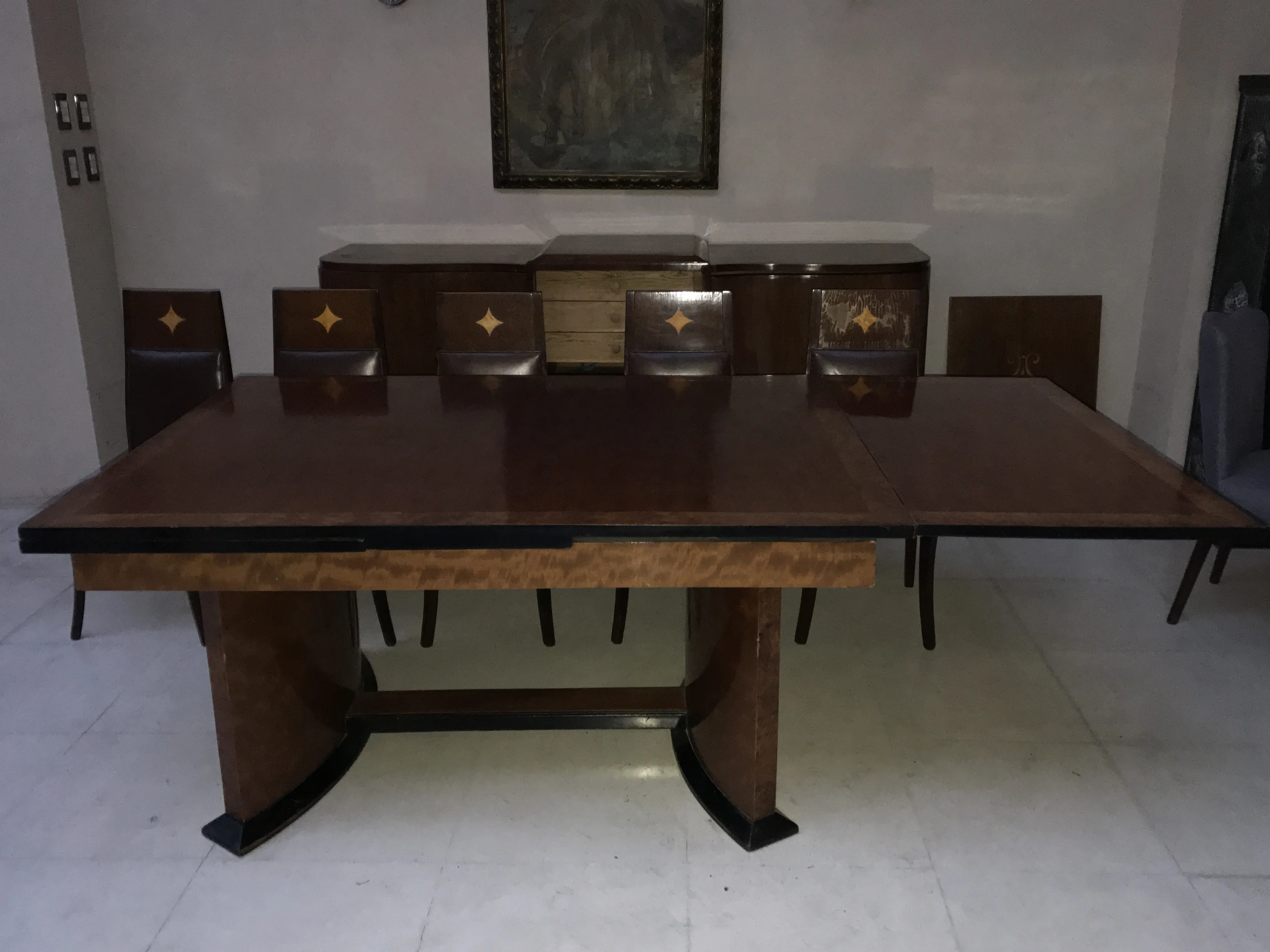 Mesa de jantar antiga para 12 pessoas em ambiente elegante.