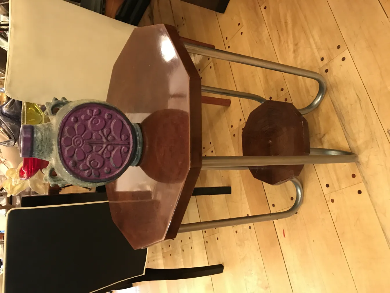 Antiga cerâmica com desenho floral e acentos coloridos sobre uma mesa.