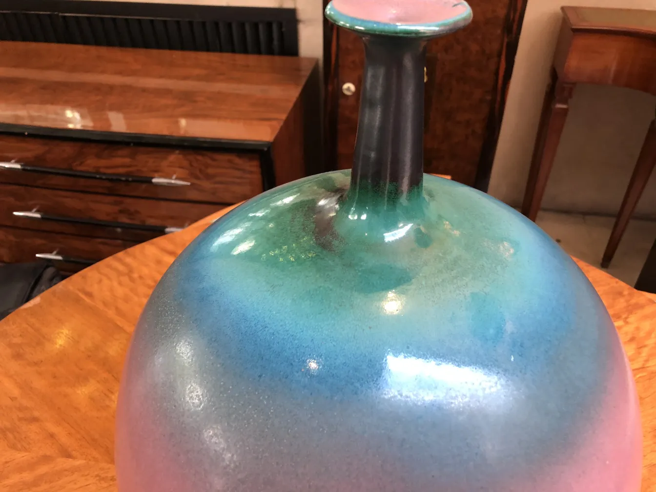 Vaso de cerâmica antiga com cores vibrantes e brilho suave.