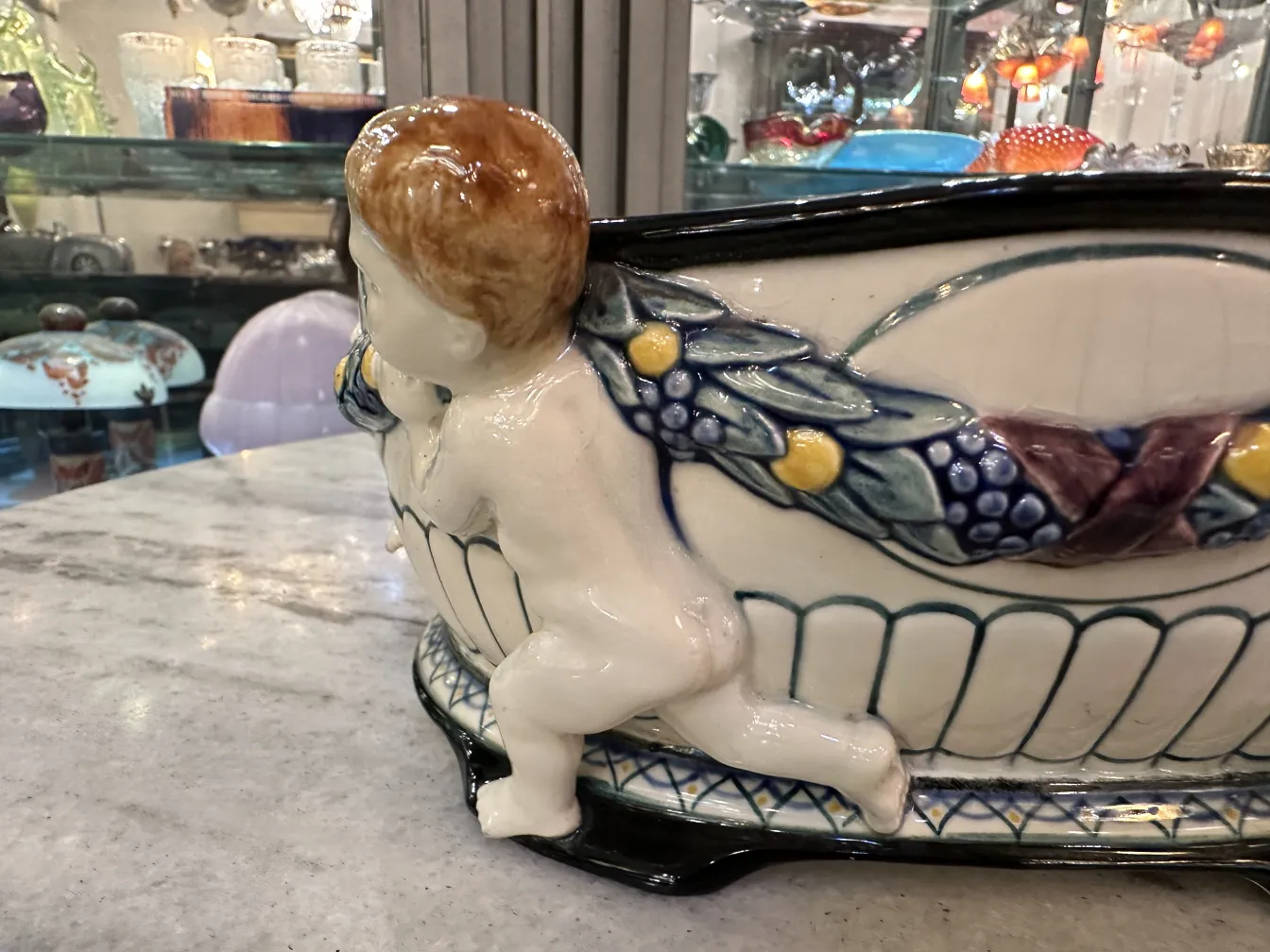 cerámica antigua decorada con un niño y hojas