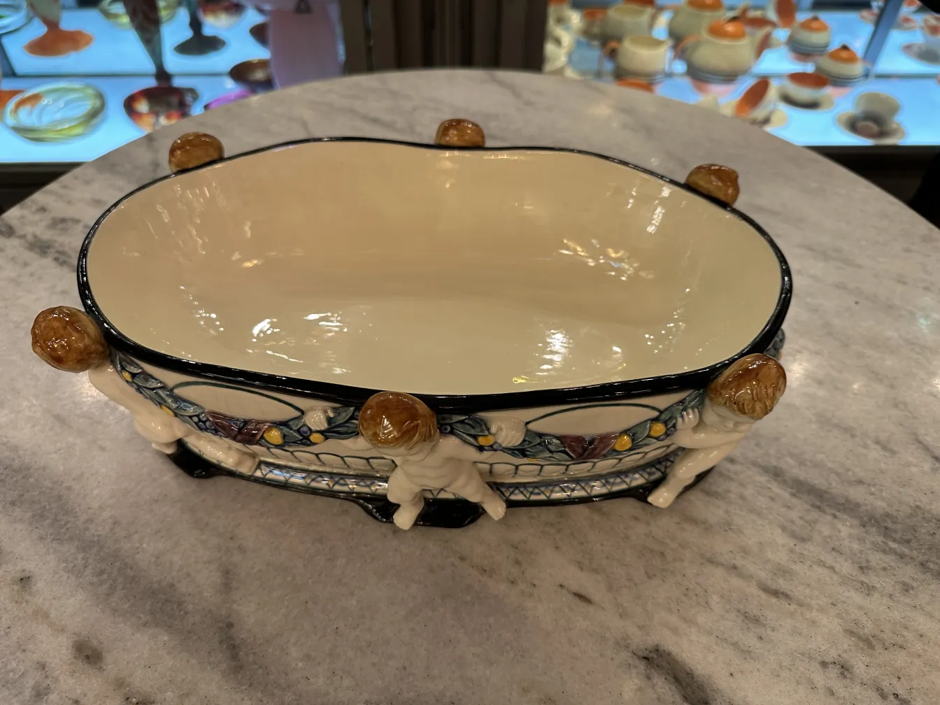 Antike Keramikschüssel mit figürlichen Details und buntem Dekor.