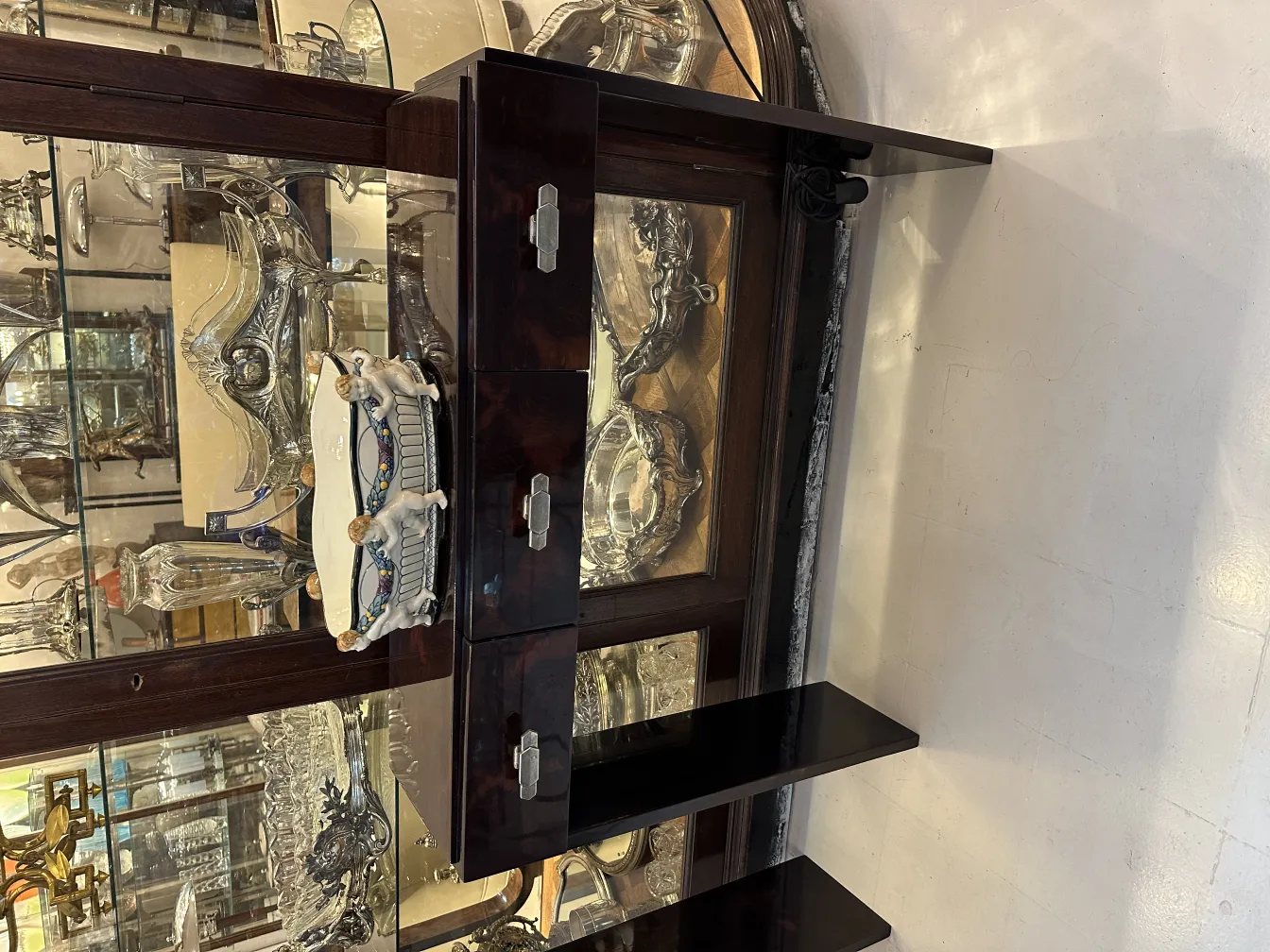 古代装饰白色陶瓷，带有彩色细节，背景为银色物品。