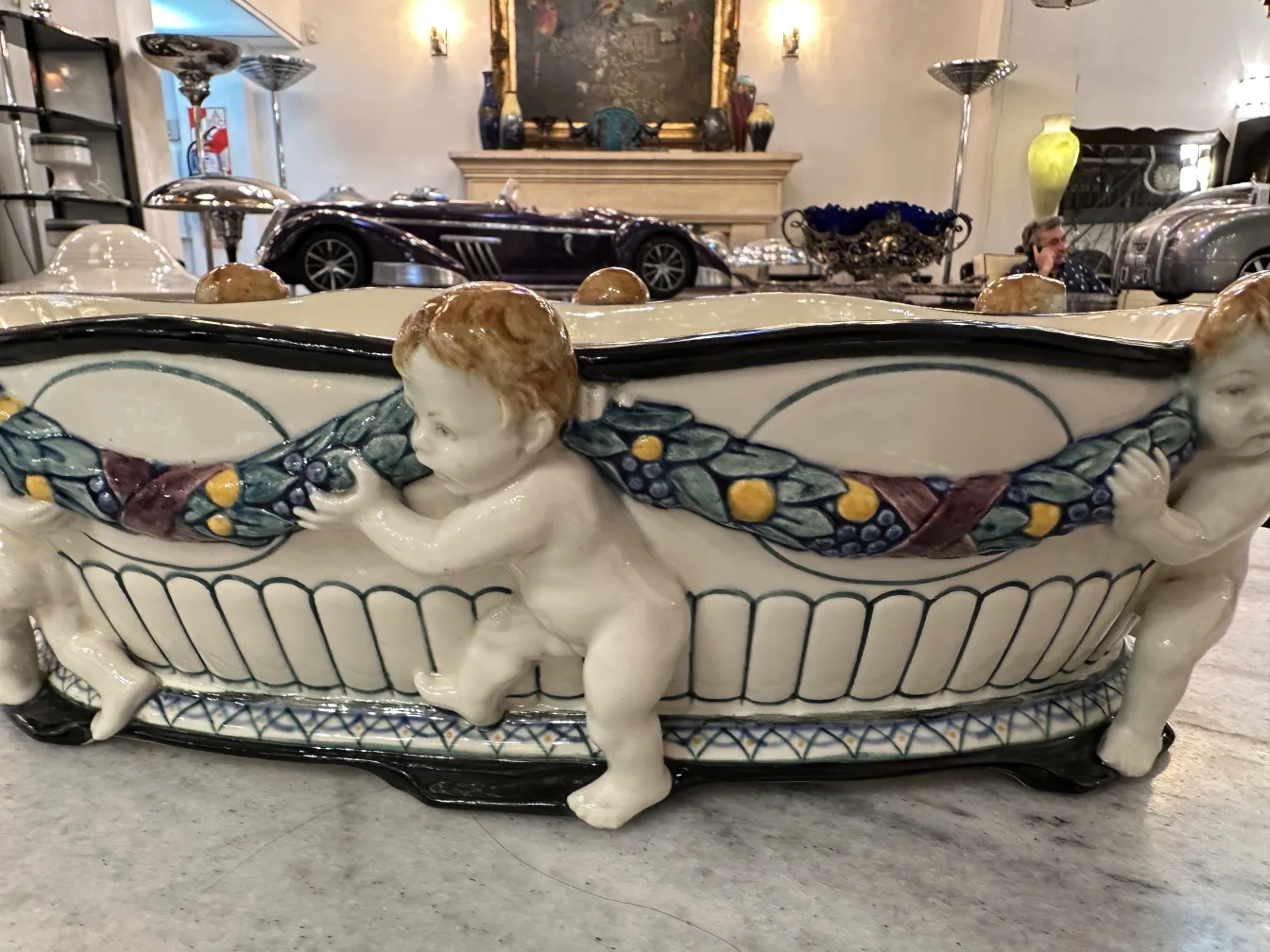 Antica ceramica con figure di bambini e decorazione colorata.