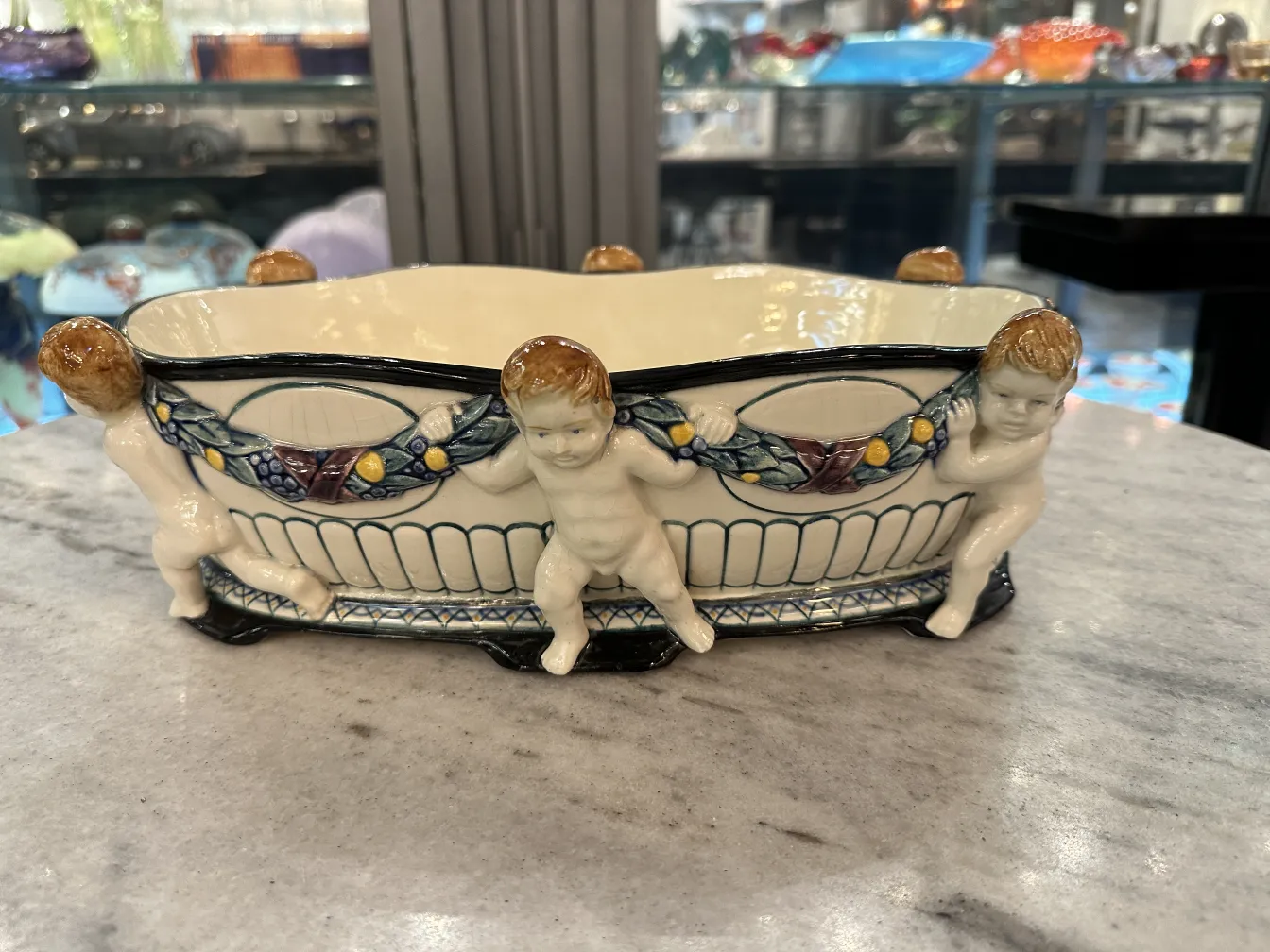 Antike Keramik mit Kinderfiguren und buntem Dekor.