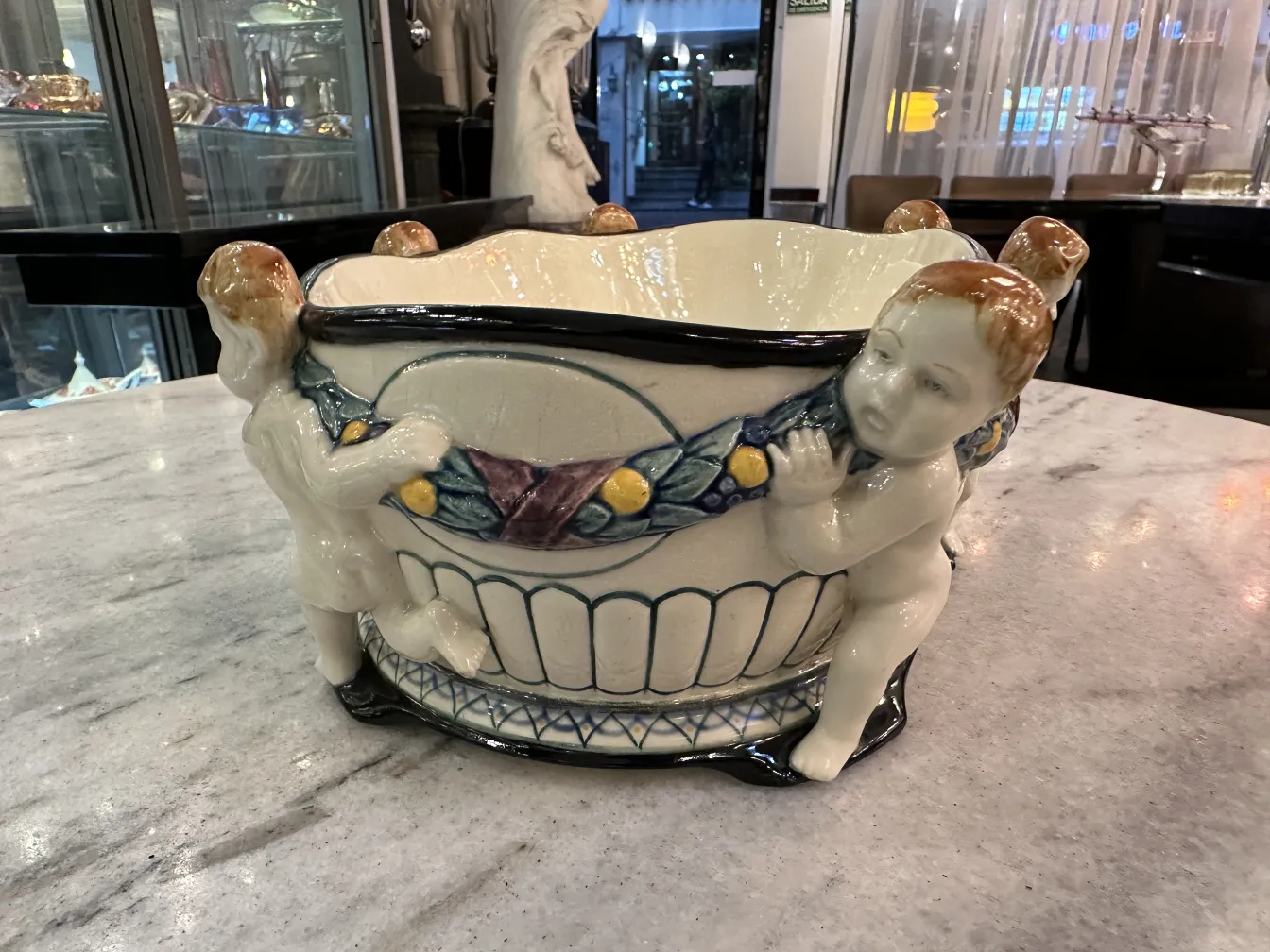 Antique ceramic featuring cherub figures in an appealing design.