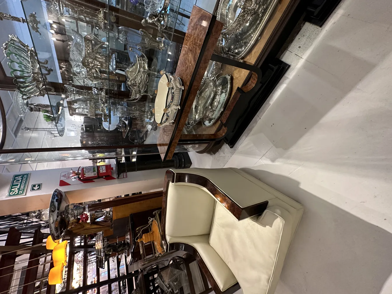 Antigua cerámica decorativa en una vitrina con objetos plateados