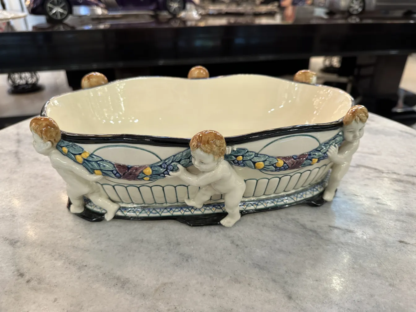 cerámica antigua decorativa con figuras de niños adornando