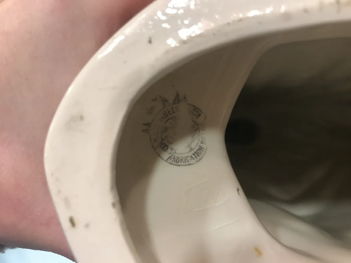 Cerâmica antiga decorativa branca com detalhes visíveis.