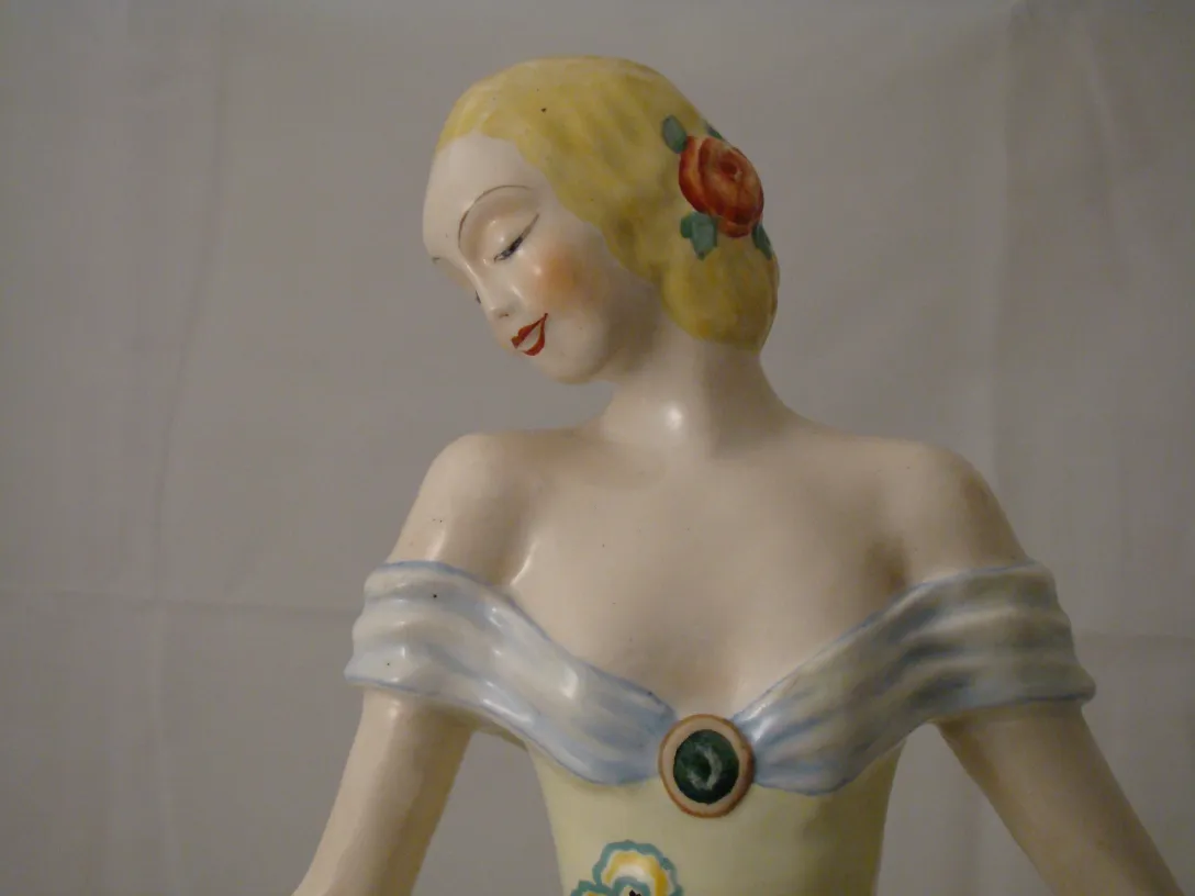 Antike dekorative Keramikfigur mit floralen Details und klassischem Kleid