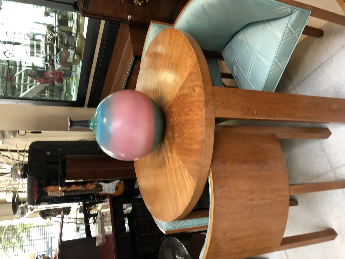 jarrón de cerámica antigua en tonos rosa y azul sobre mesa de madera