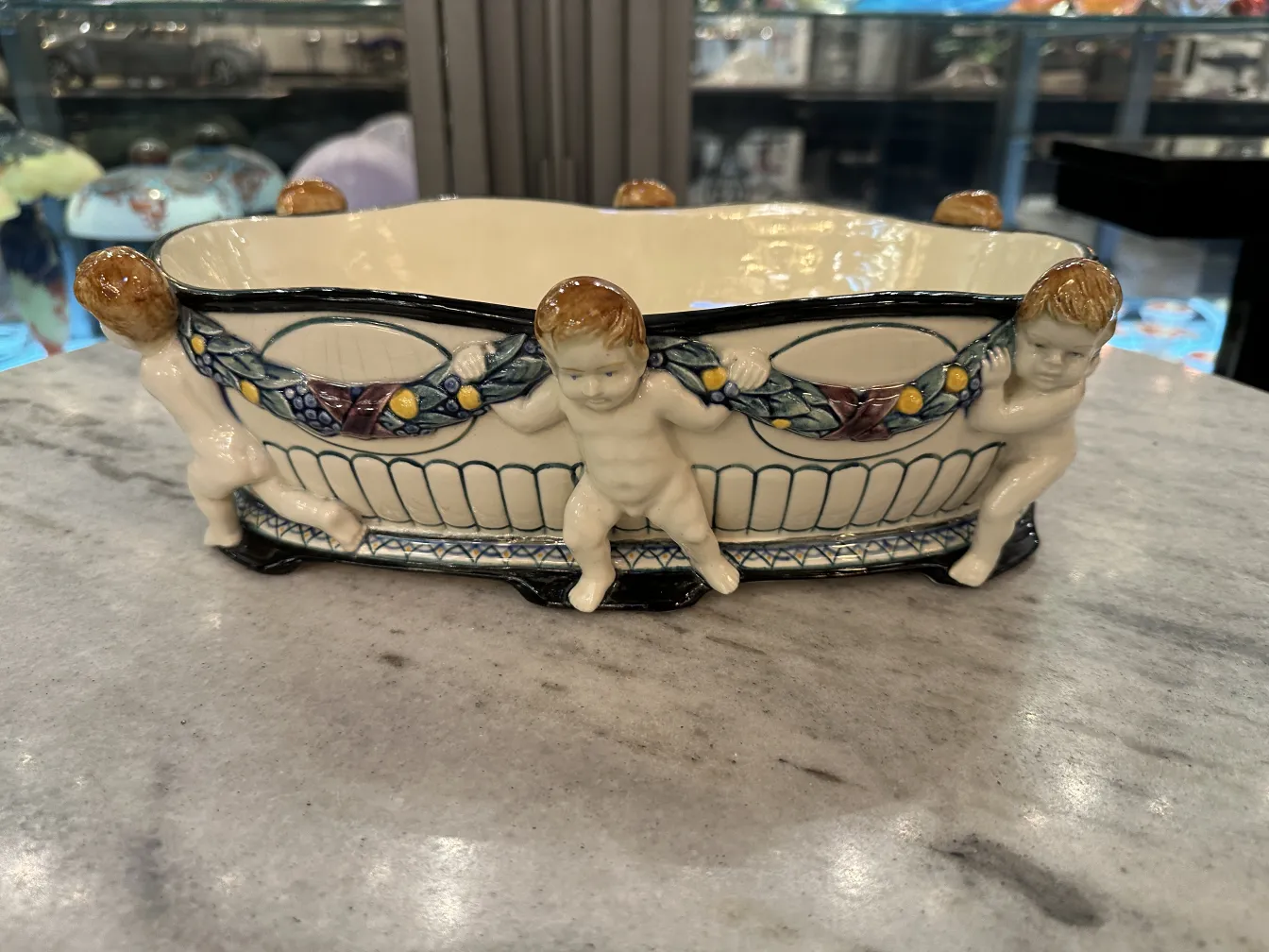 Antike Keramik mit Kinderfiguren, weiß mit blauen Details.