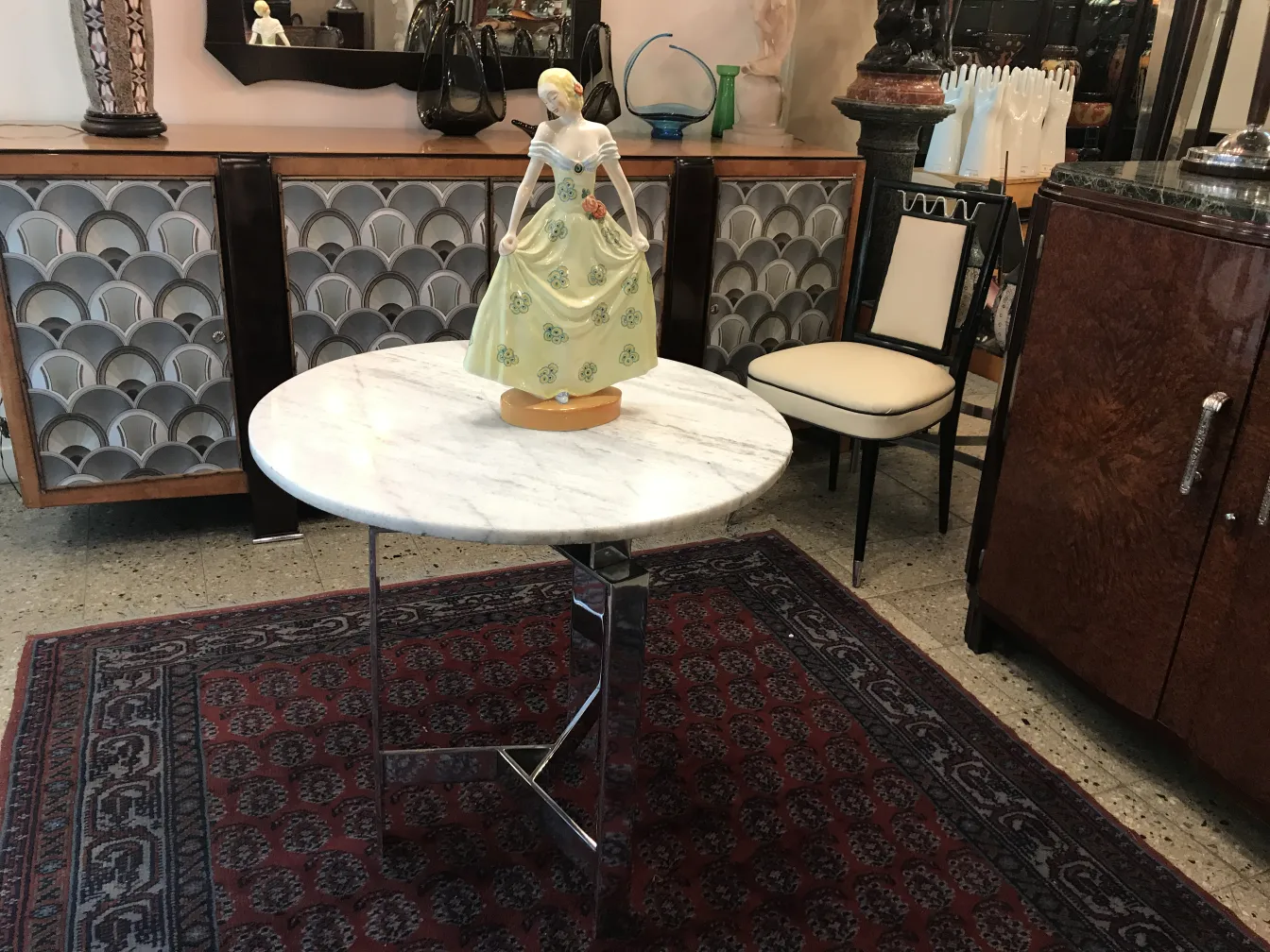 Antique ceramic decorative figure with colorful dress on table.