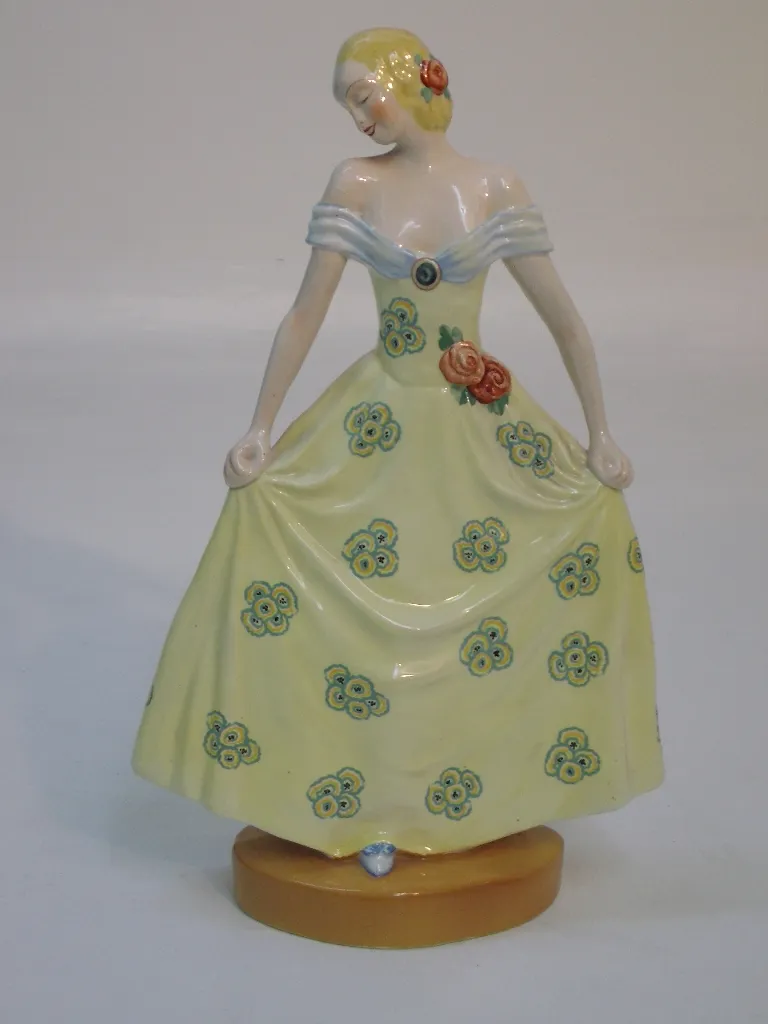 figura antica in ceramica con vestito giallo e fiori