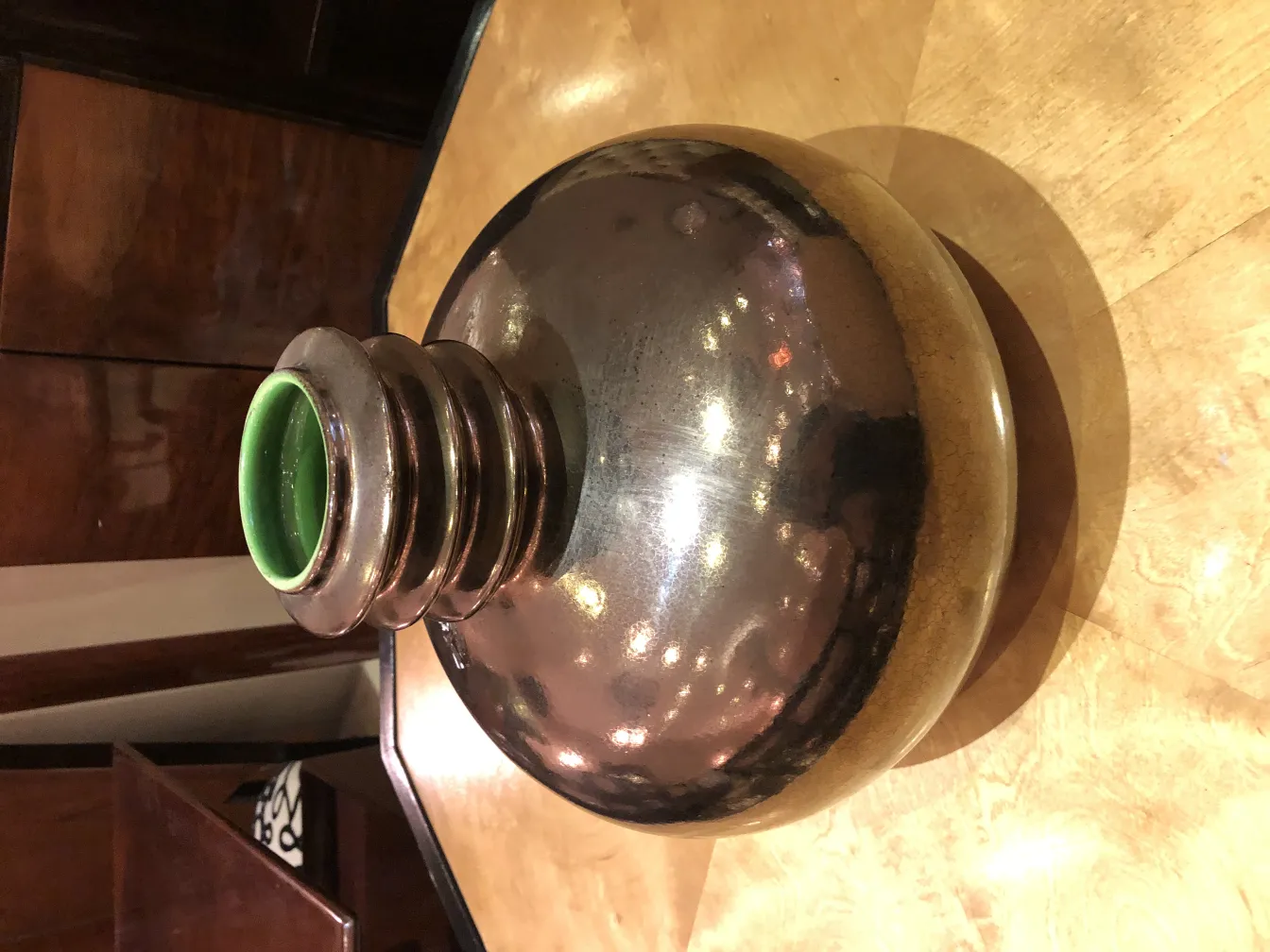 古い陶器の光沢仕上げ、緑色のディテールが縁にあり、木製のテーブルの上にあります。