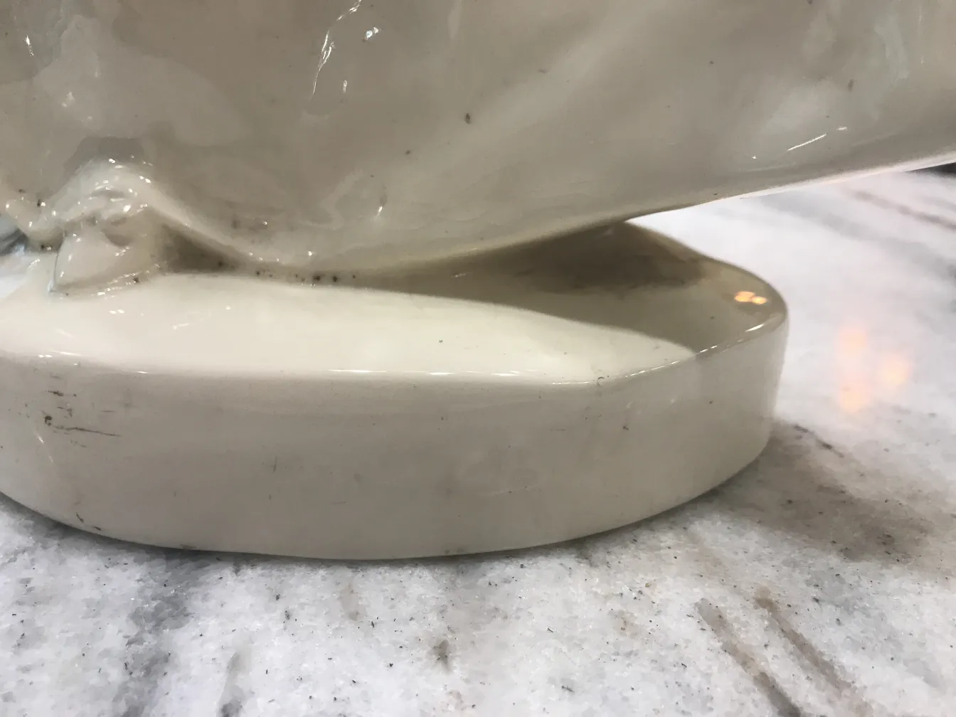 Ancienne céramique avec émail blanc et finition brillante, base arrondie.