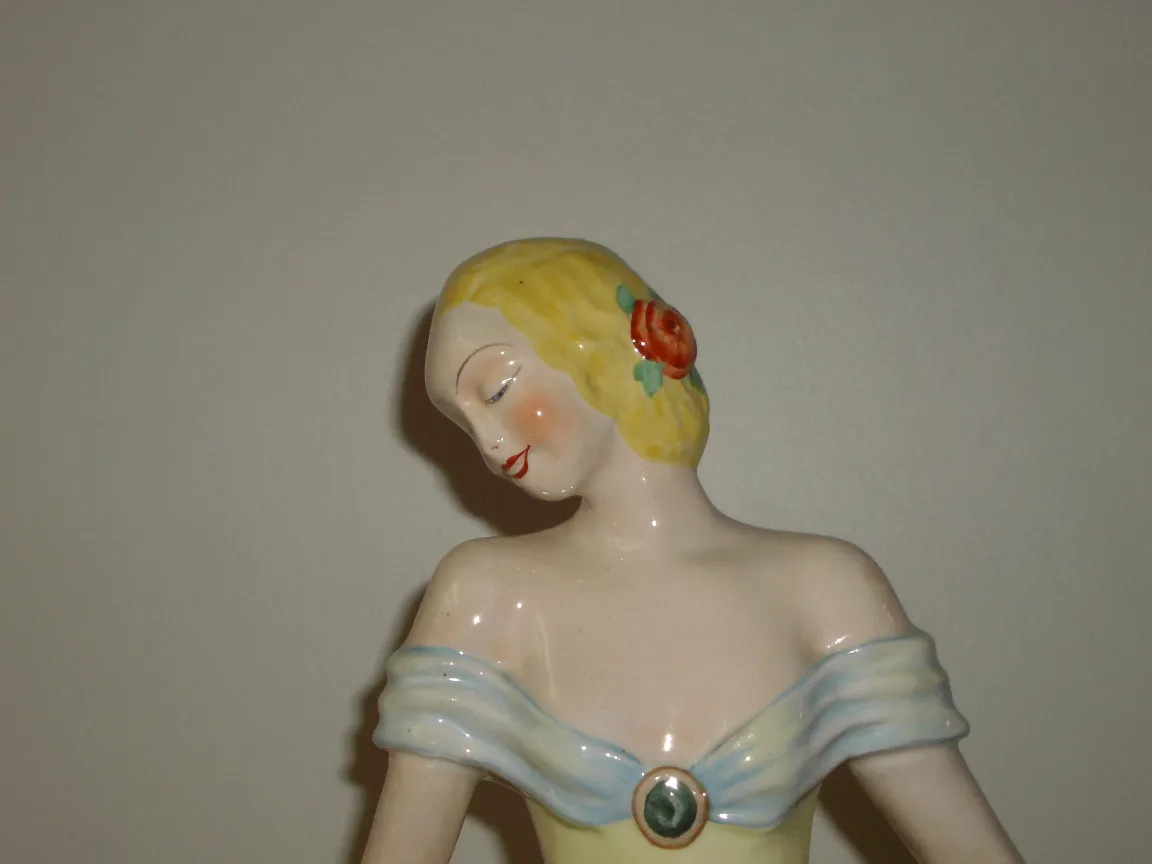 Figurine en céramique ancienne avec des détails colorés et des traits délicats.