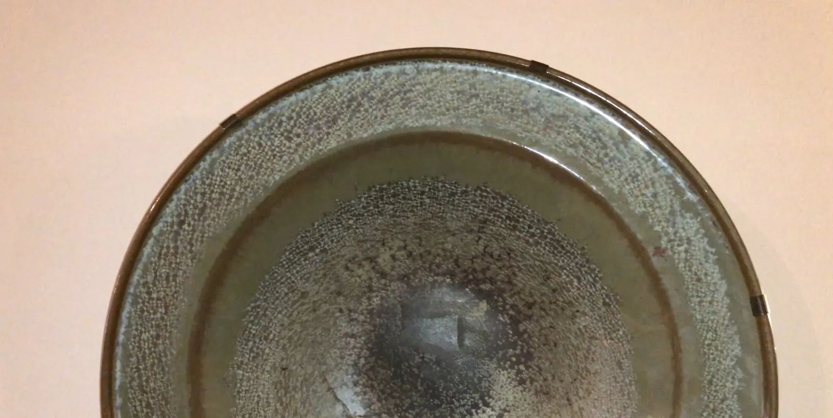 céramique ancienne avec un design circulaire et une texture décorative.