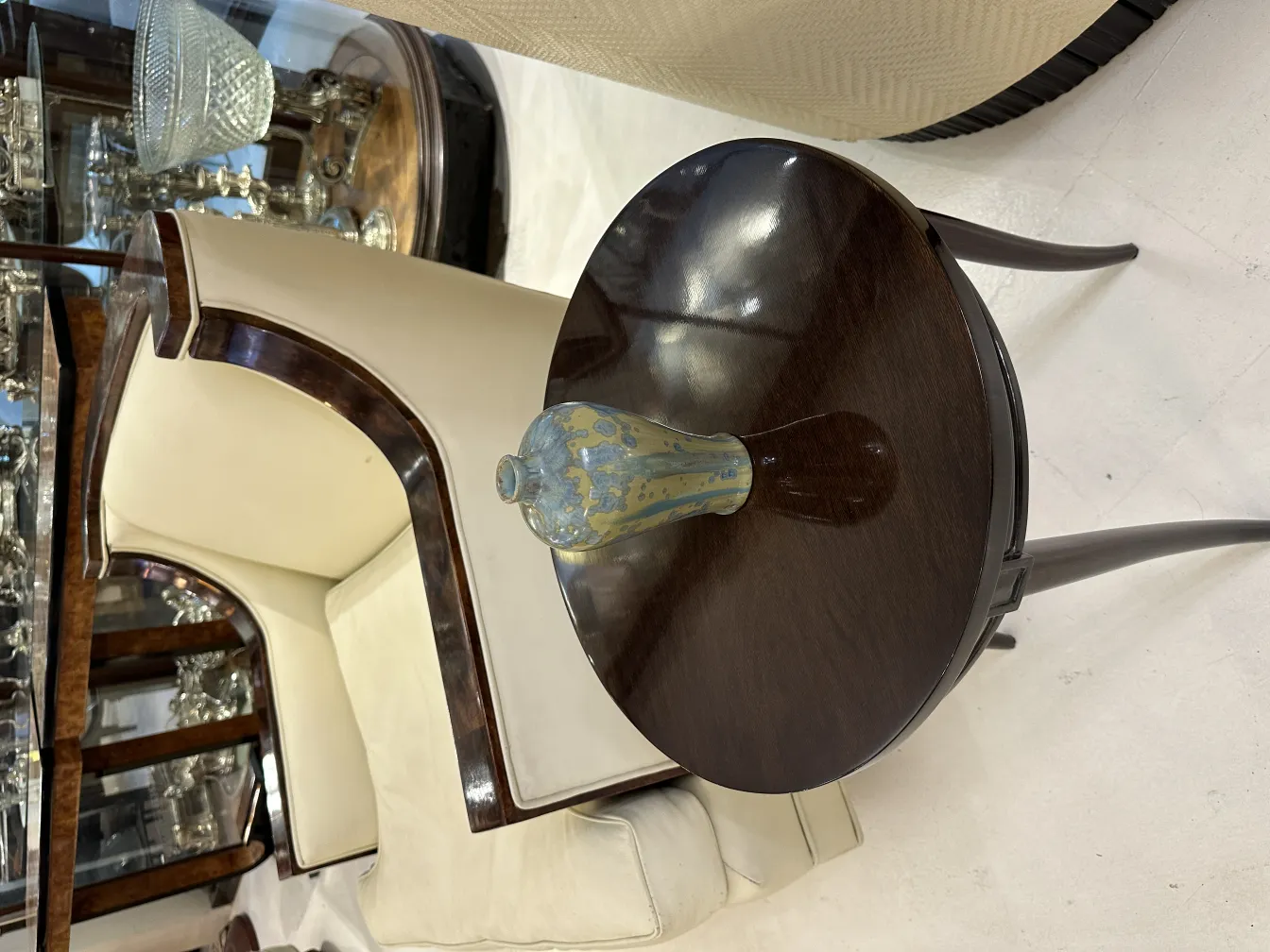 سيراميك تزييني قديم على طاولة دائرية داكنة، إعداد أنيق