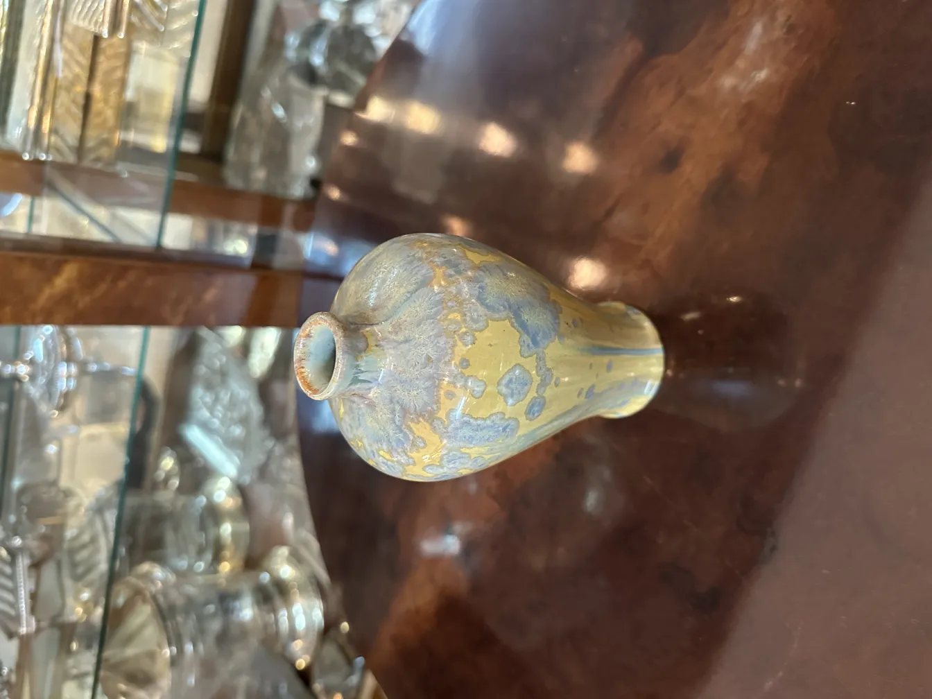 vasque en céramique antique avec des détails bleus et jaunes, fond neutre