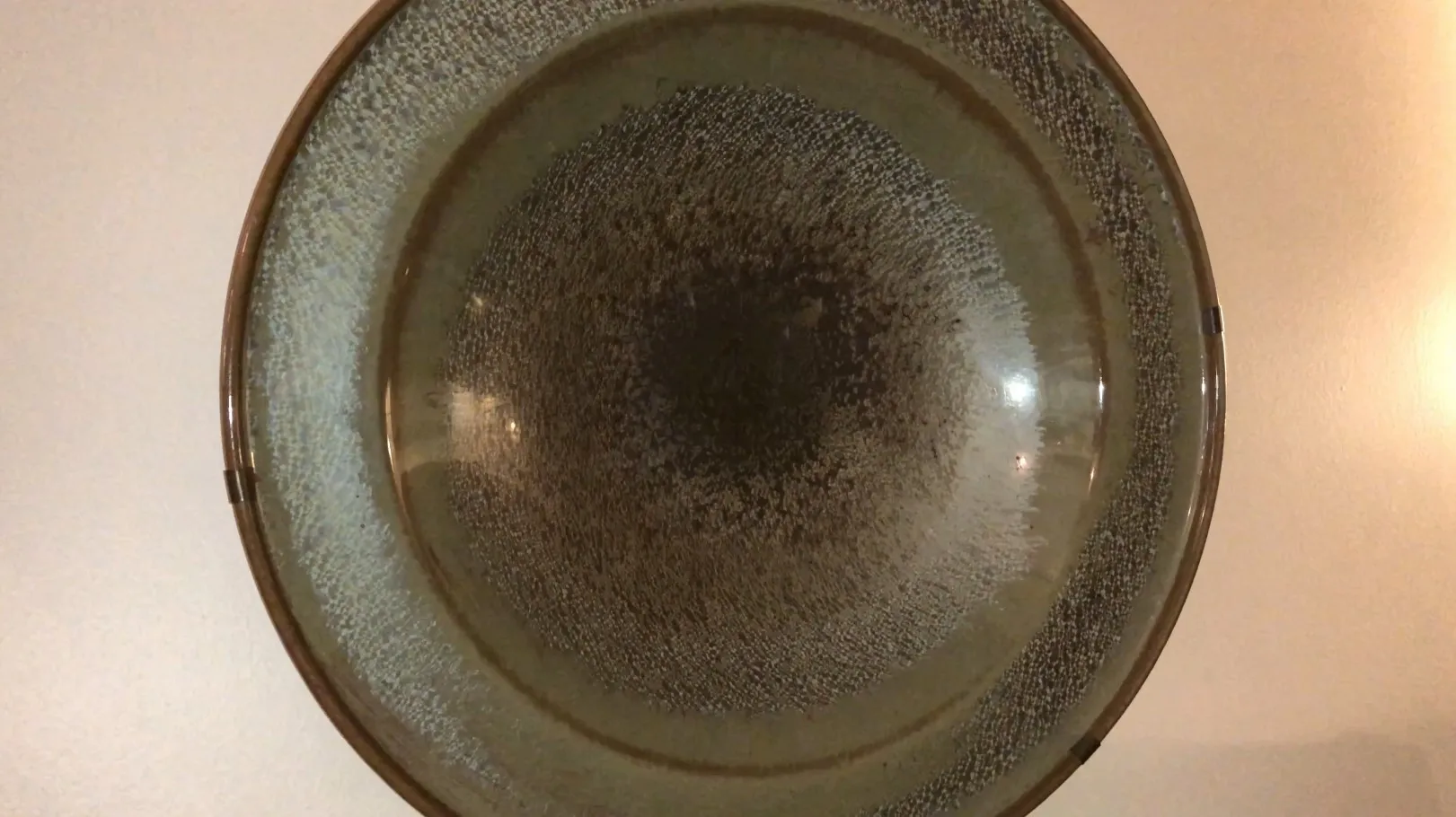 さまざまな色の表面を持つ古い円形の陶器の皿。