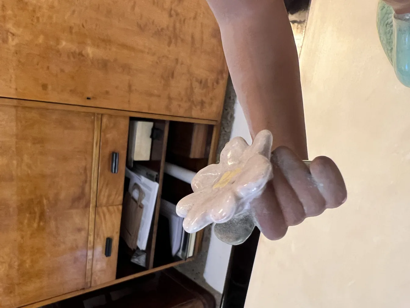 cerâmica antiga em forma de flor, cores suaves, fundo natural