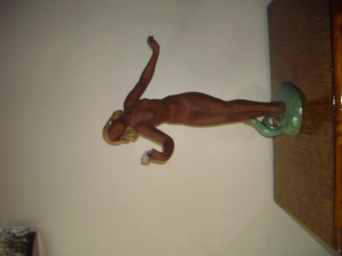 Scultura antica in ceramica, figura femminile con base verde.