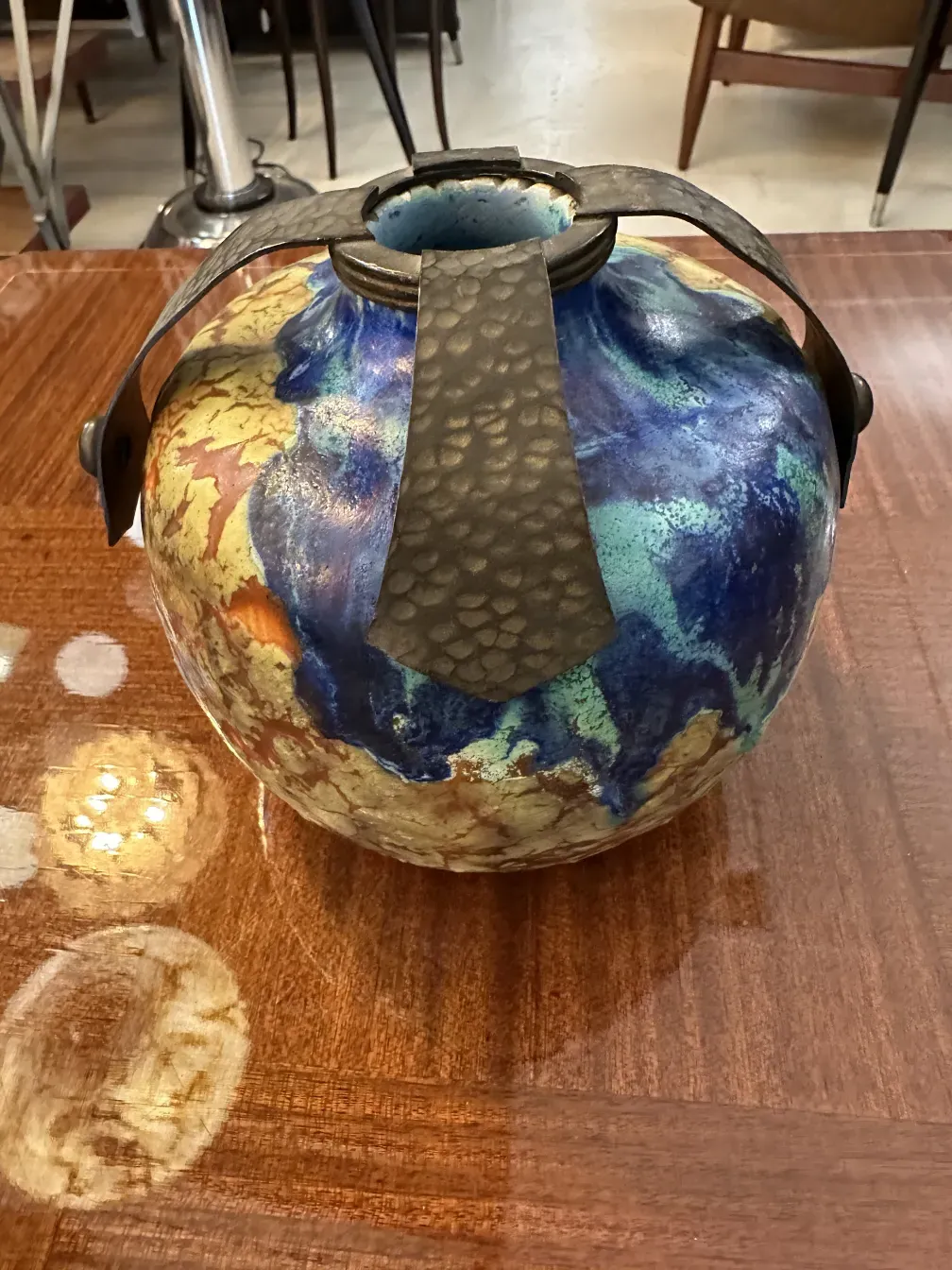 Vue supérieure d'une céramique ancienne avec des couleurs vives et un design frappant, fond de table en bois brillant.