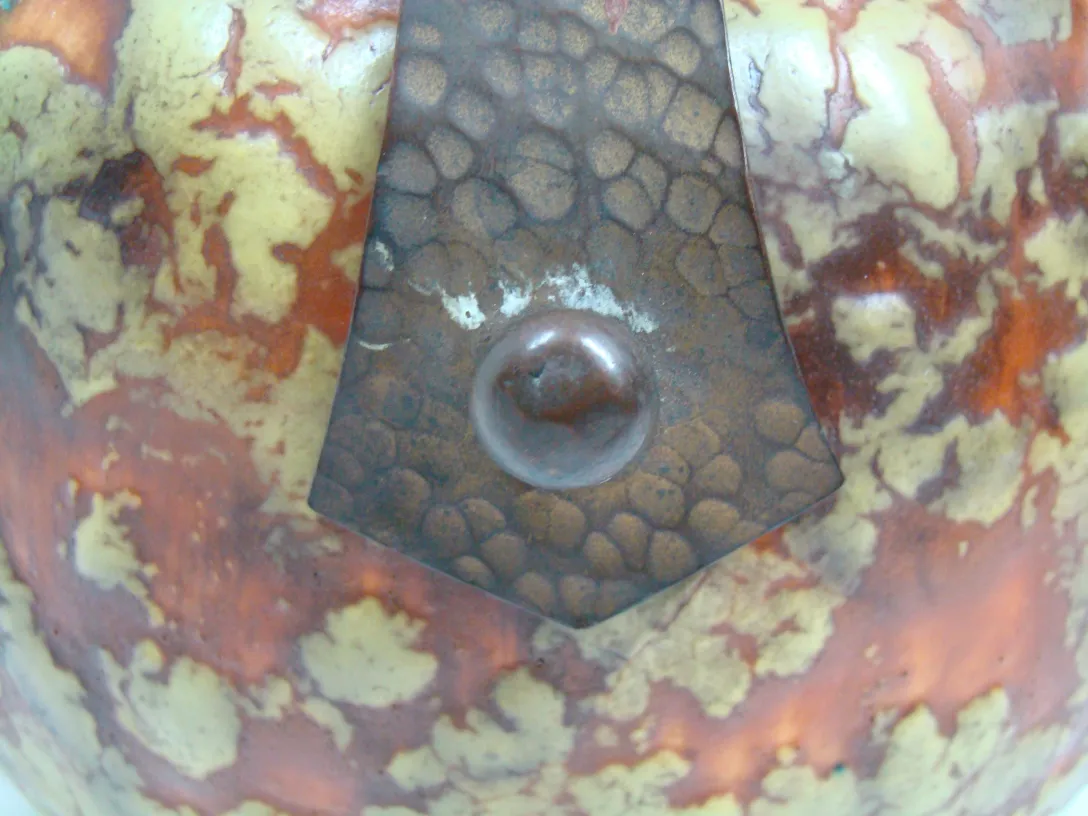 Antigua ceramica decorativa con tonos marrones y amarillos