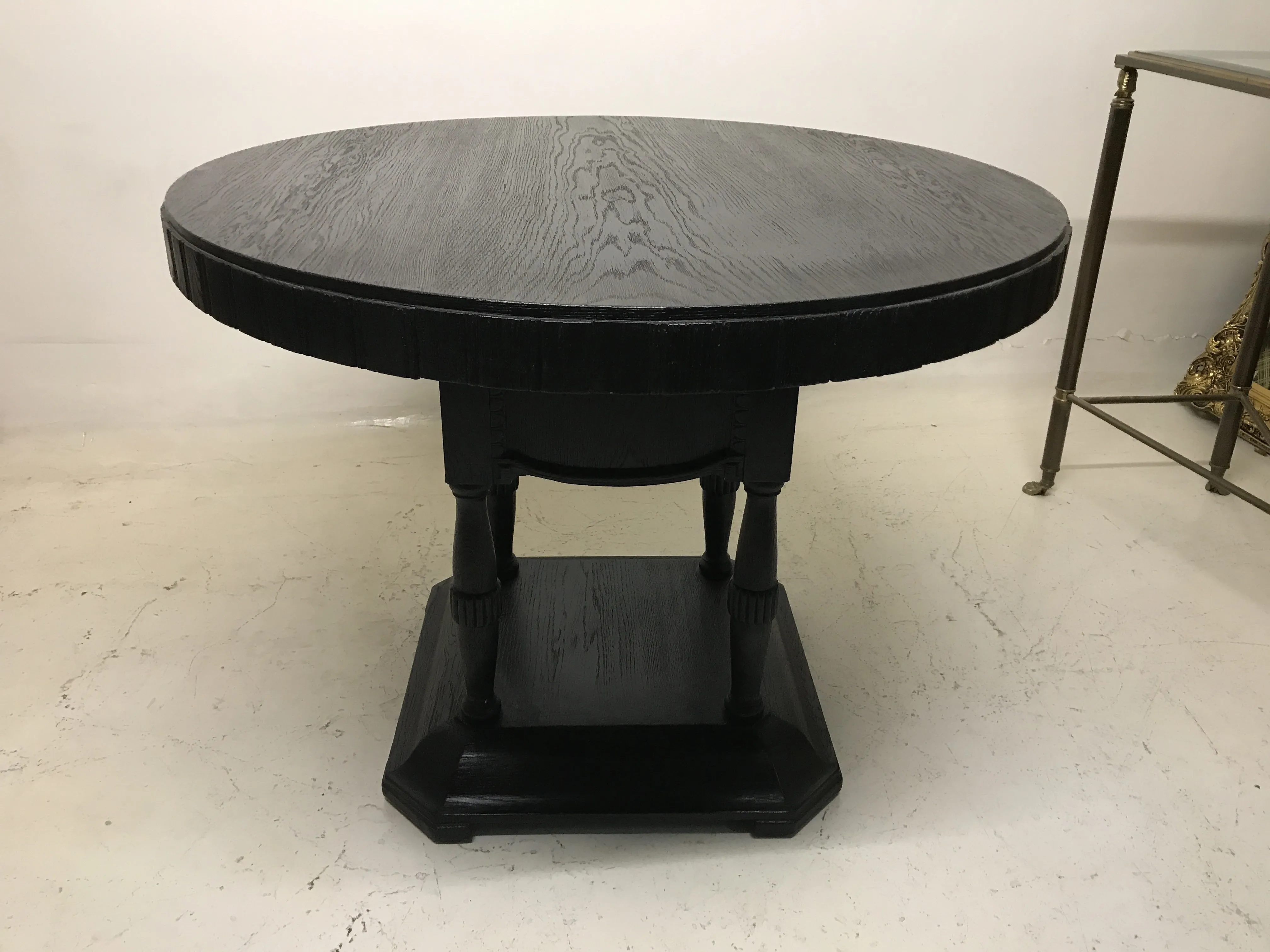 Mesa redonda antiga para duas pessoas em um ambiente minimalista.