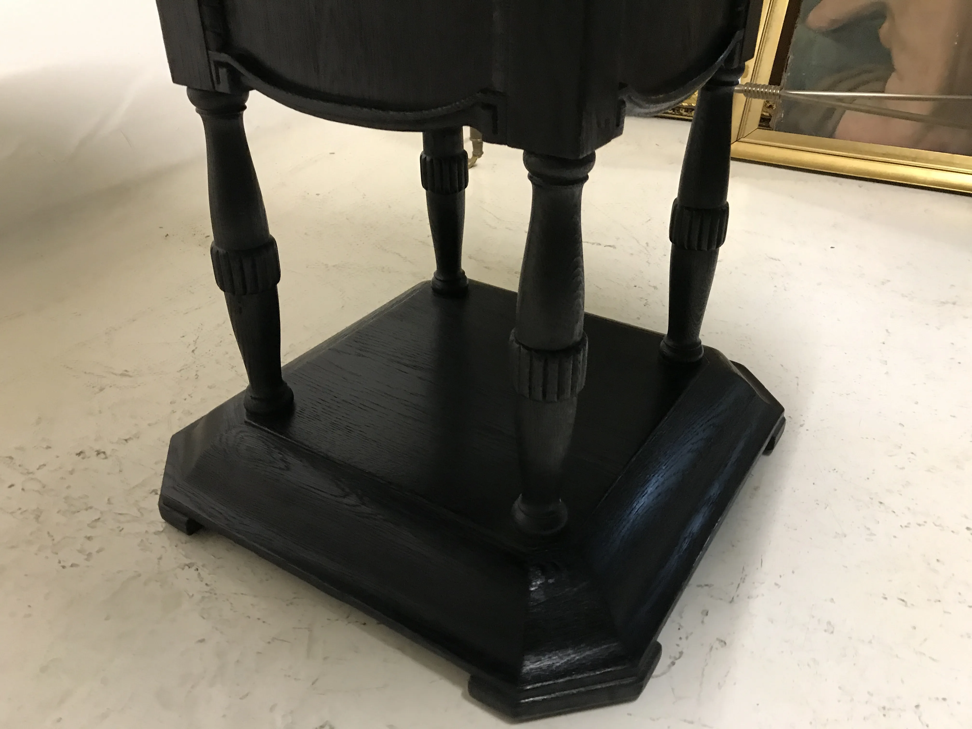 mesa antigua con base elegante y patas estilizadas, entorno acogedor