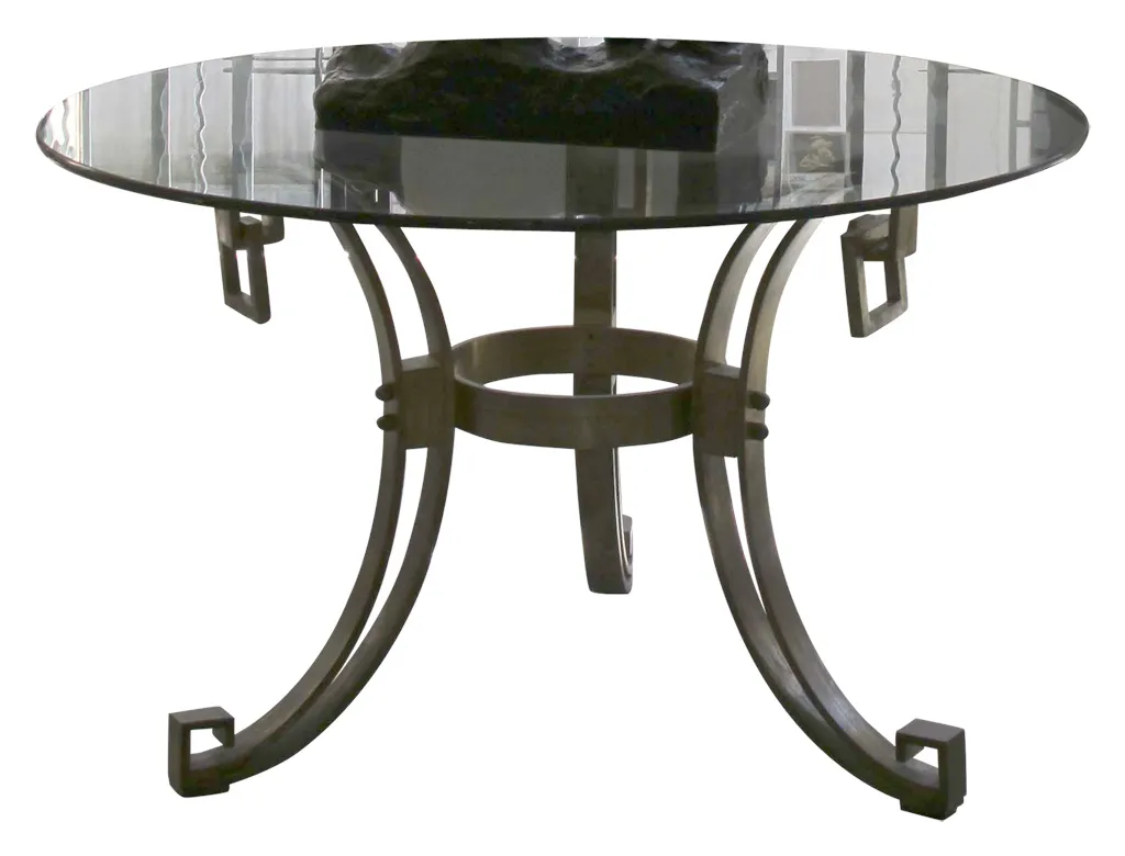 mesa de comedor antigua art deco con forma redonda para 4 personas, decorada con un objeto negro en el centro.