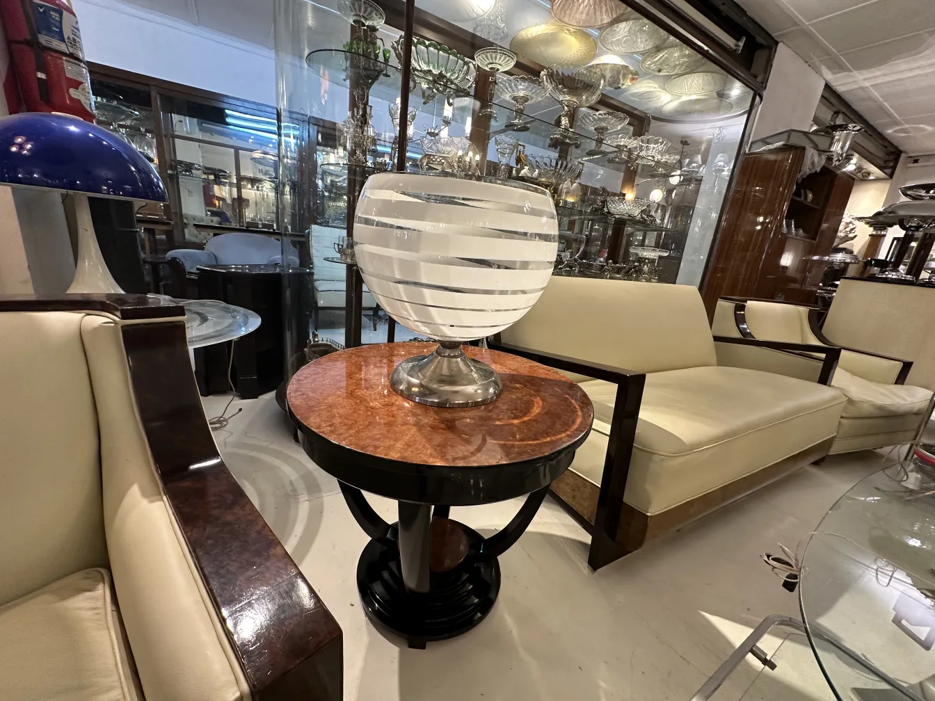 Lampada da tavolo antica con base decorativa in argento, in un ambiente di antiquariato.