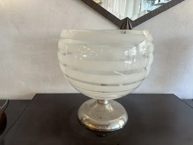 Antique table lamp with striped design and silver base, enhancing a dark furniture piece.