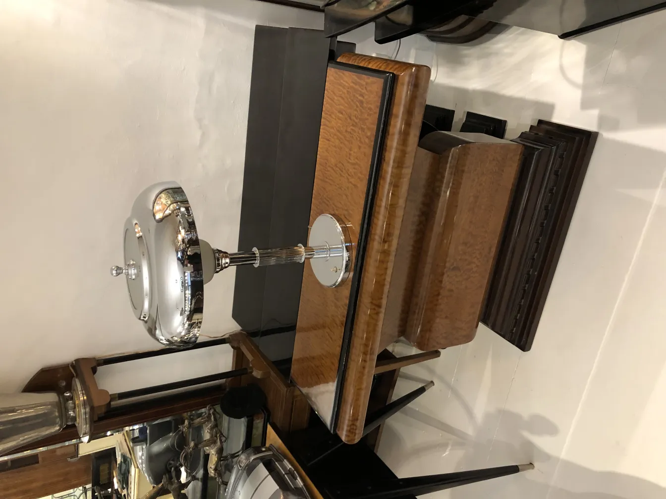 lampada da tavolo antica con base lucida e design elegante in un'ambientazione di antiquariato