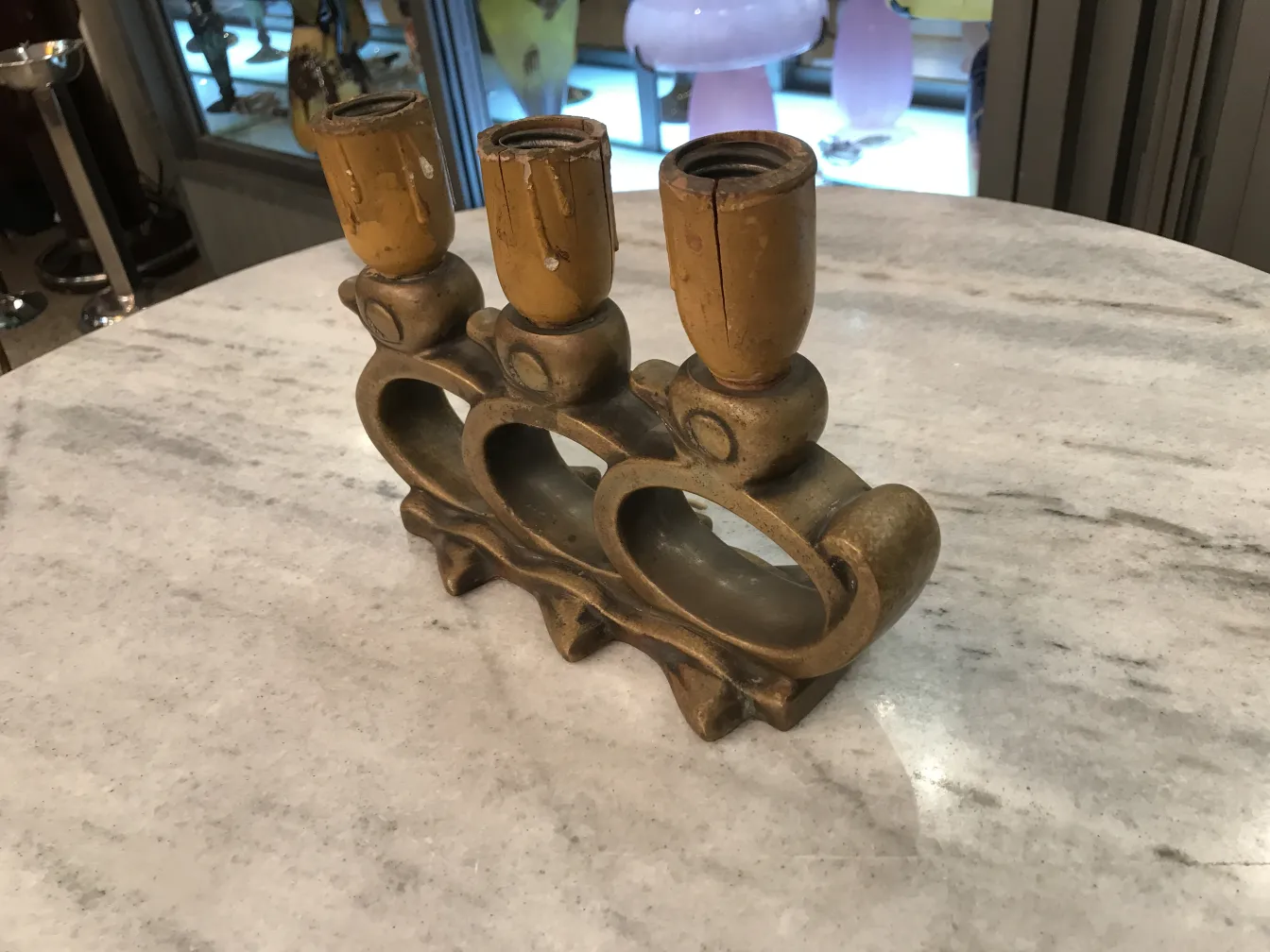 Lámpara de mesa antigua con tres bases de soporte en una mesa