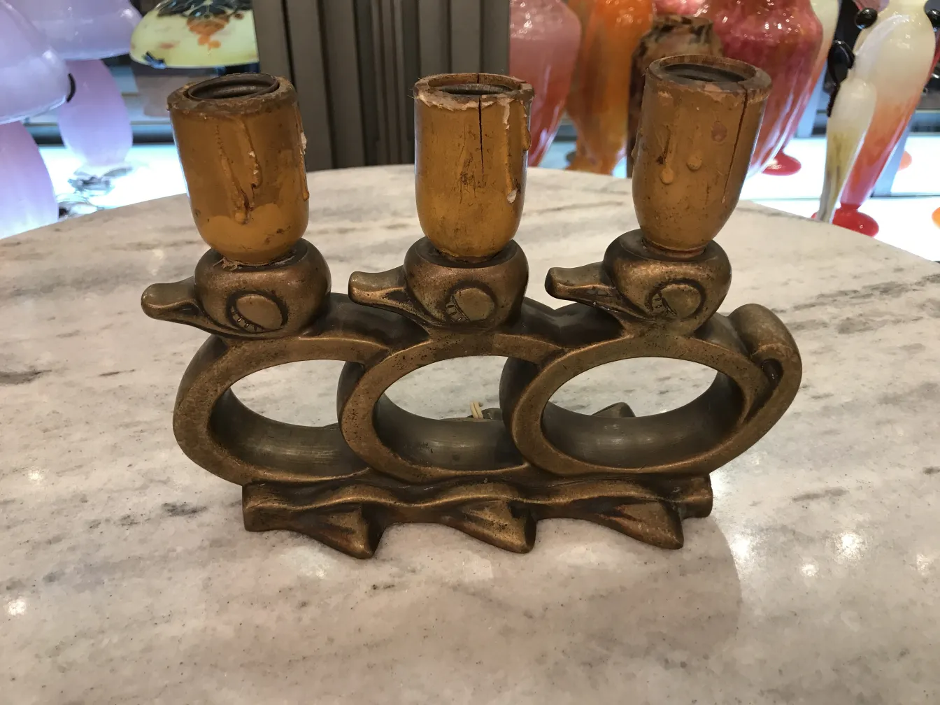 Lampada da tavolo antica con tre animali in bronzo e lampadine gialle, decorando uno sfondo luminoso