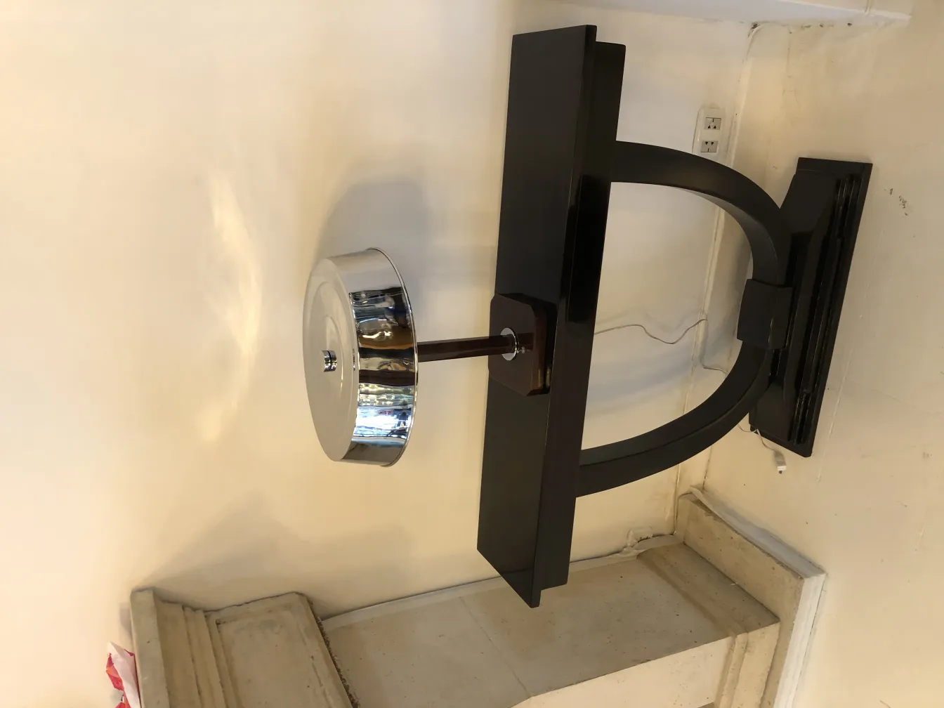 lampada da tavolo antica con base nera e paralume lucido in una stanza chiara