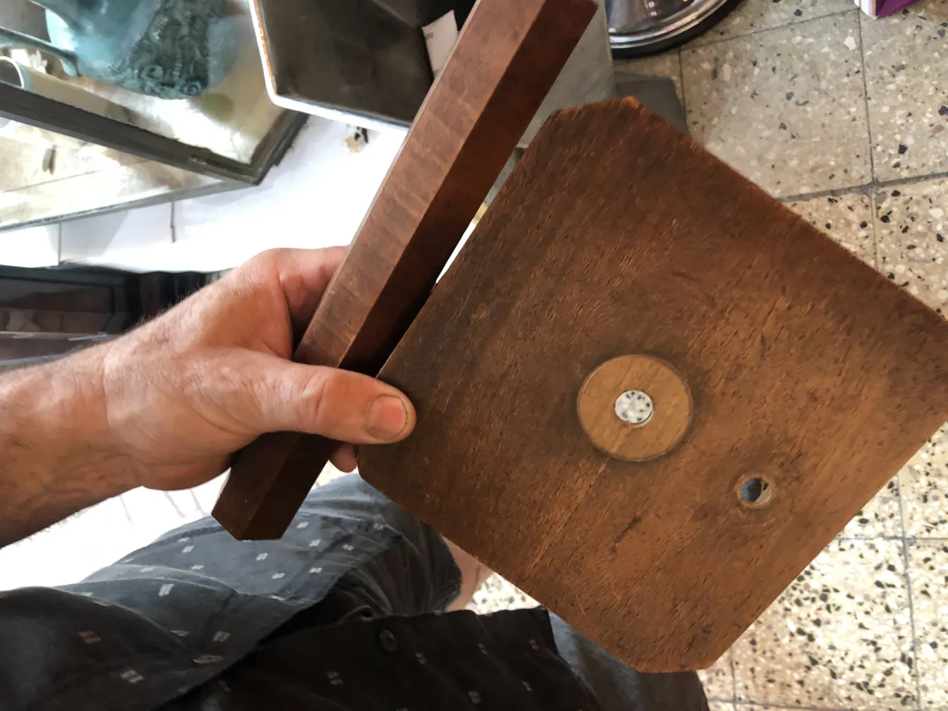 Lampe de bureau ancienne avec un design simple et une base rectangulaire, en main