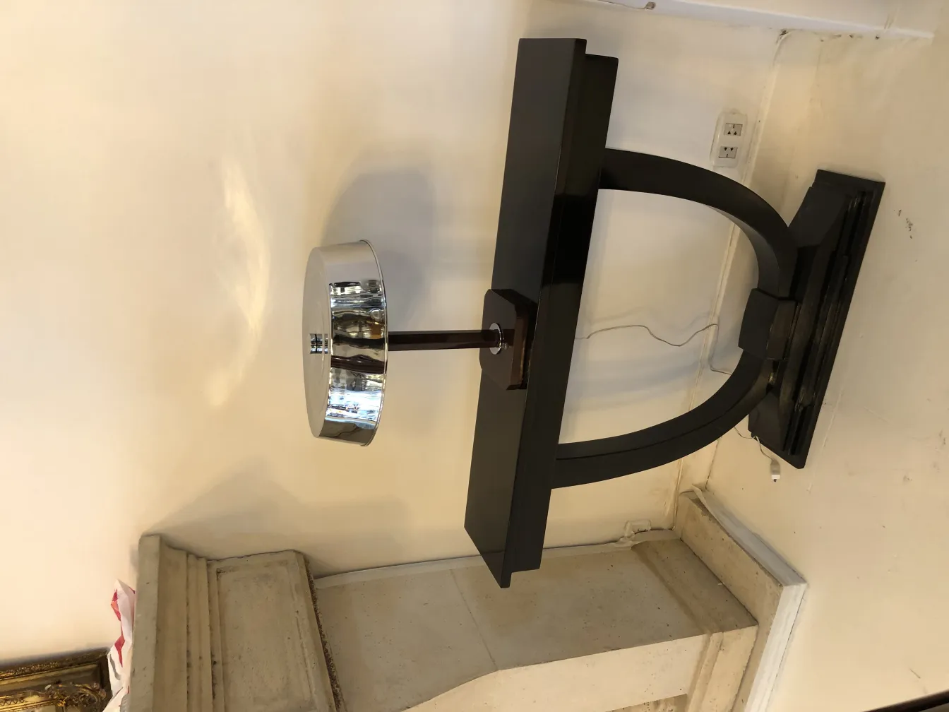 luminária de mesa antiga com base preta e cúpula cromada, em um ambiente clássico