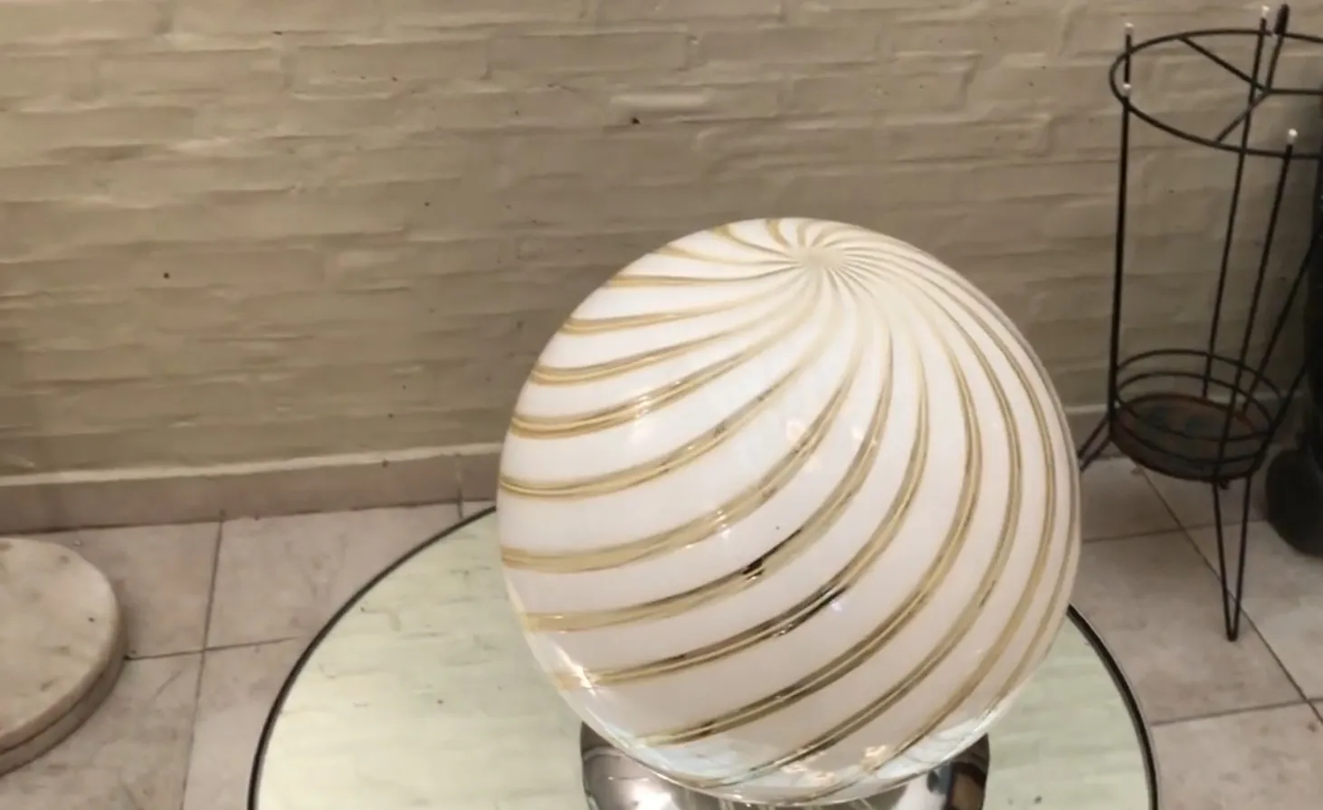 lámpara de mesa antigua con base estilizada y pantalla en espiral blanca con líneas doradas