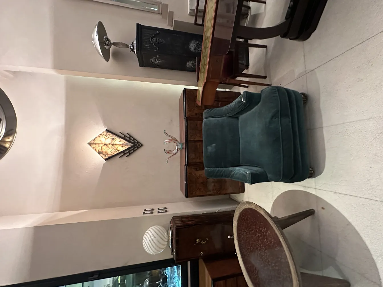 Antique table lamp with elegant design in a cozy setting, next to a chair and table.