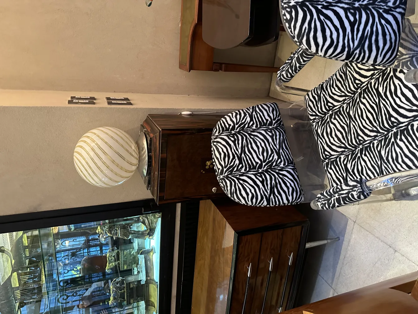 Lampada da tavolo antica con design unico in un ambiente accogliente, accanto a sedie con motivo zebra.