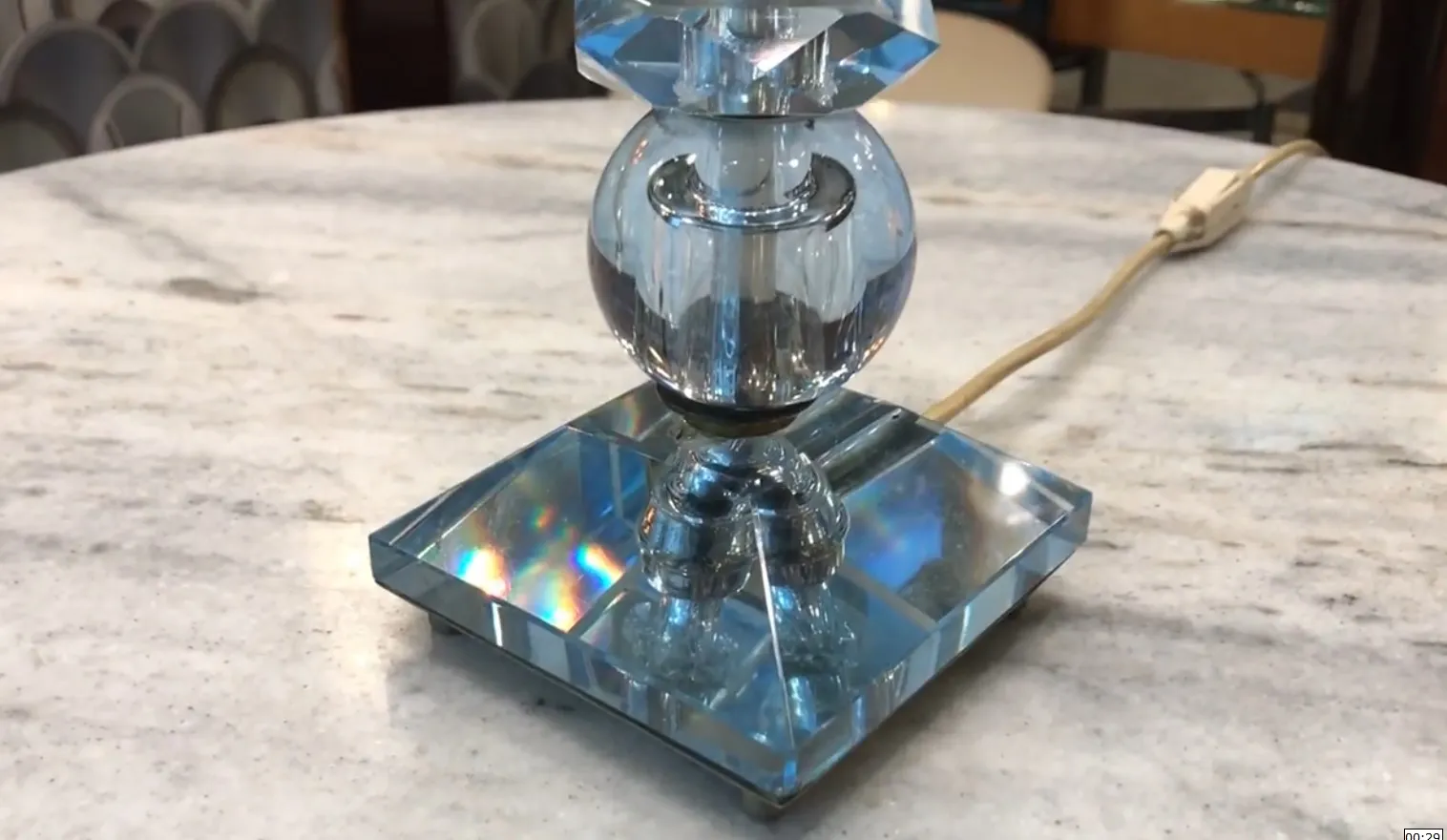 antike tischlampe mit hellen kristalldetails und reflektierender basis, die eine gemütliche umgebung beleuchtet.