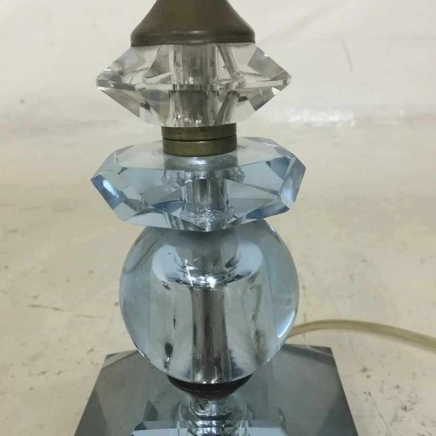 Alte Tischlampe mit dekorativen Kristalldetails, neutraler Hintergrund.