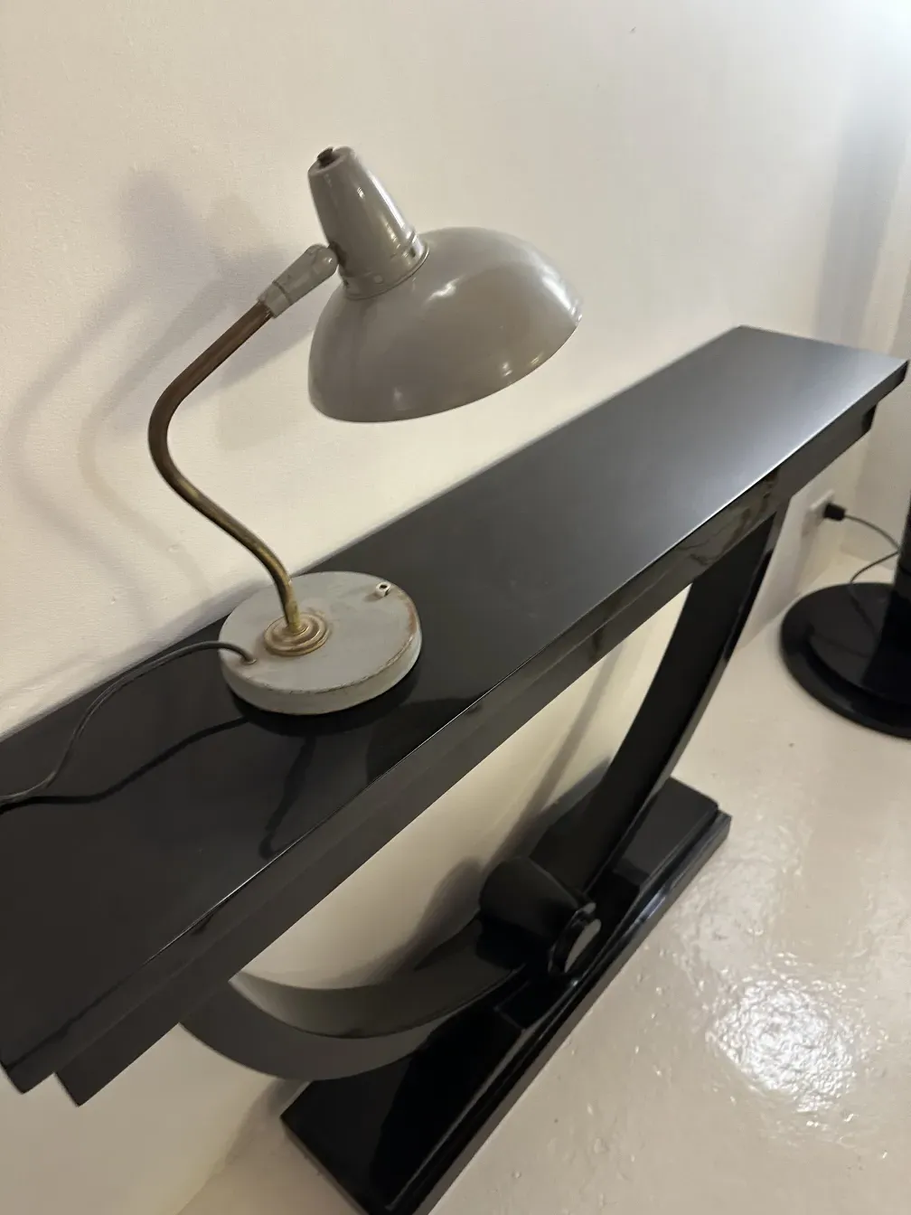 antigua lámpara de mesa de serge mouille sobre mesa negra